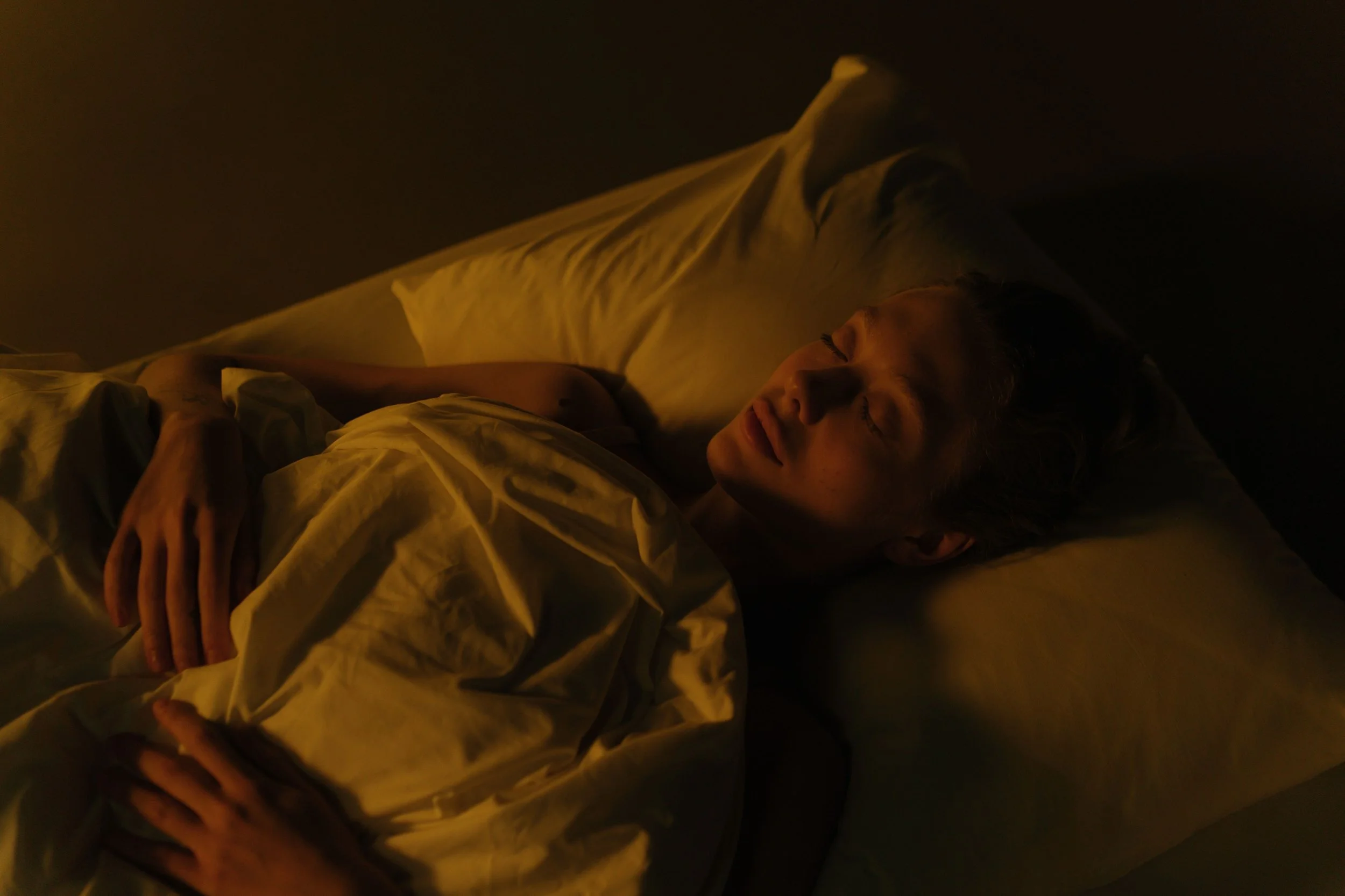 Mujer durmiendo placenteramente con una sonrisa en la cara, representando la motivación y los planes que ideamos por la noche.