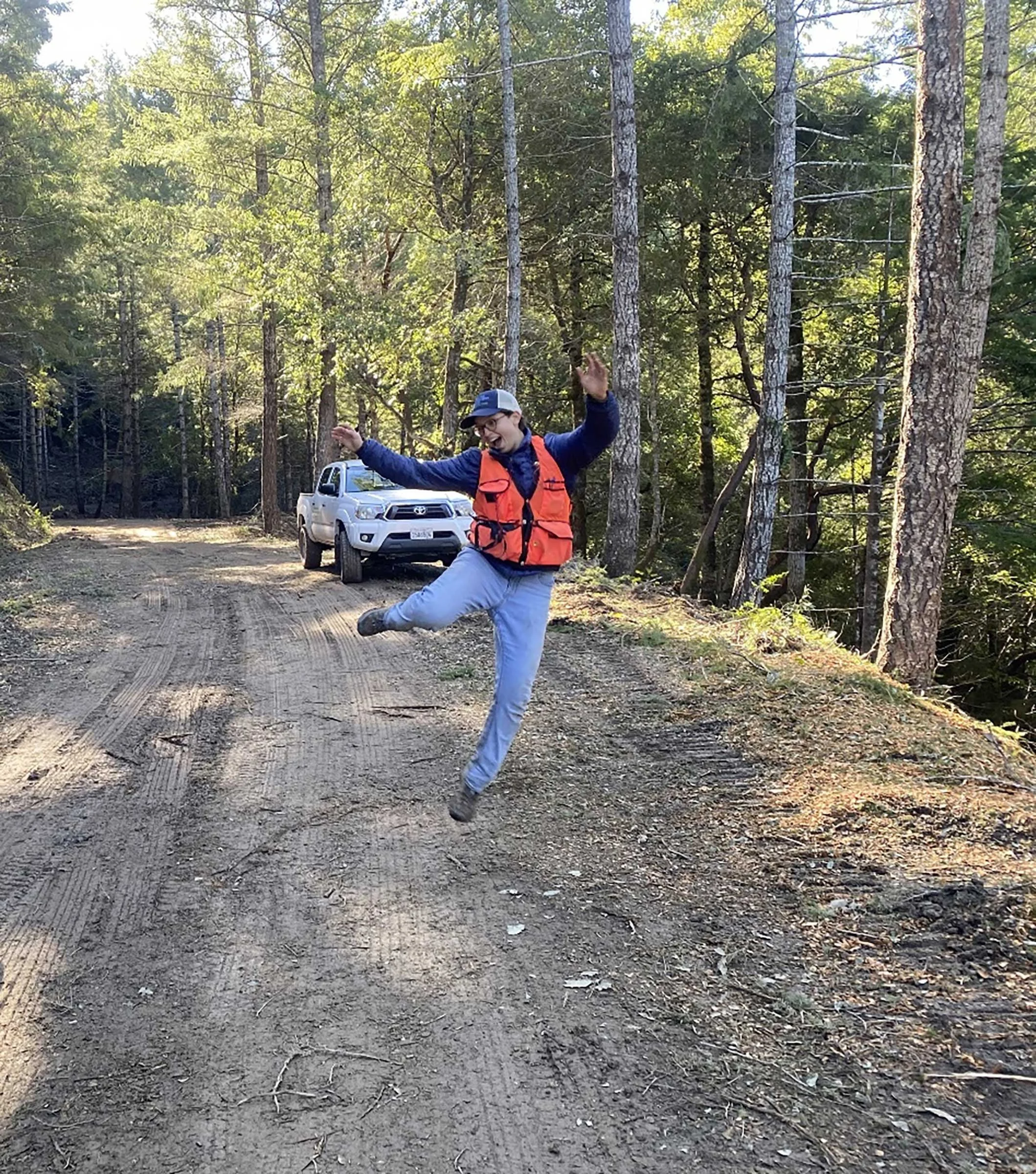 A joyful AmeriCorps volunteer helping with fuel reduction in the forest