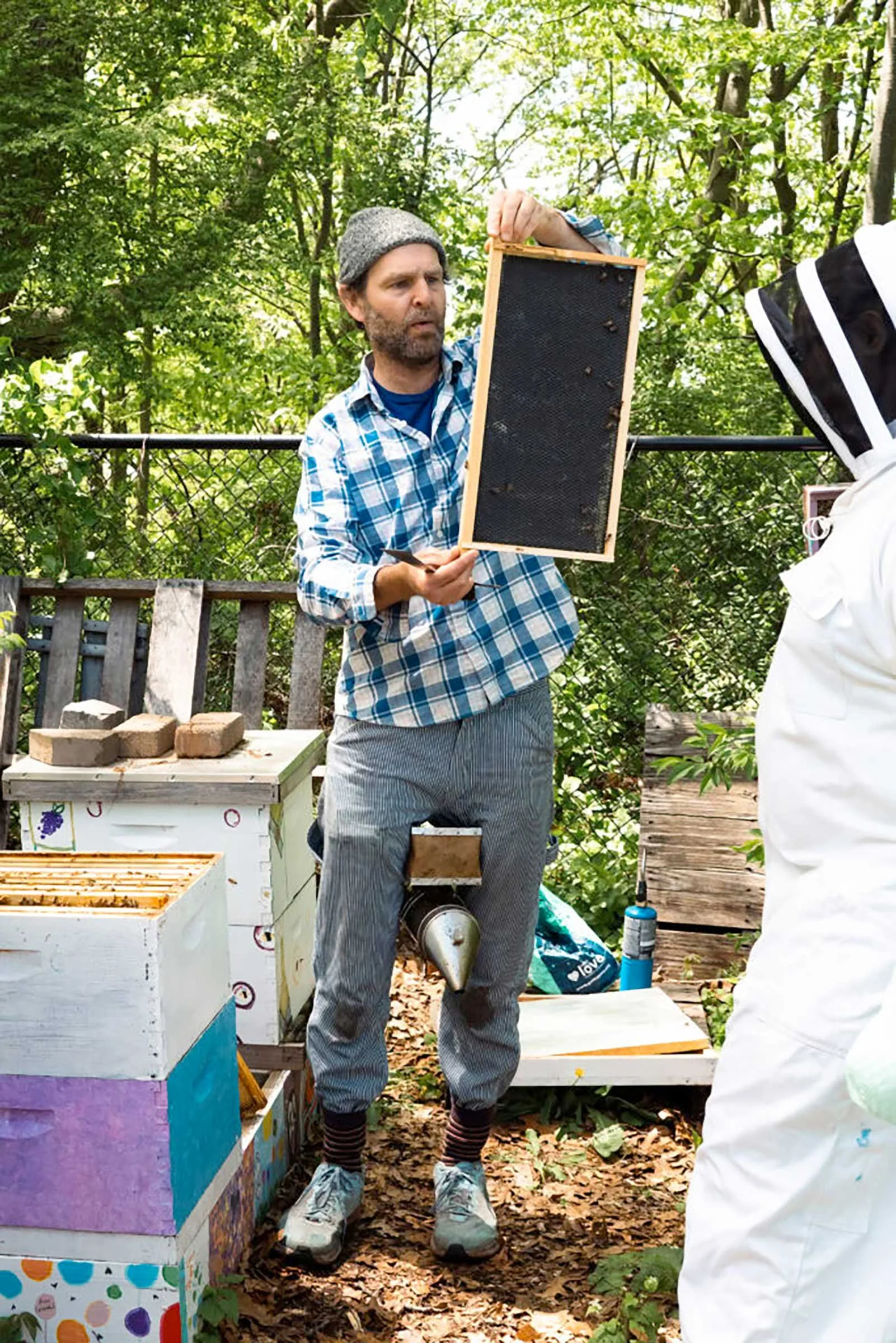 Tim Dutcher, lead beekeeping instructor for the Huneebee Project, shows off a frame during a hive check. Credit: Ben Seal