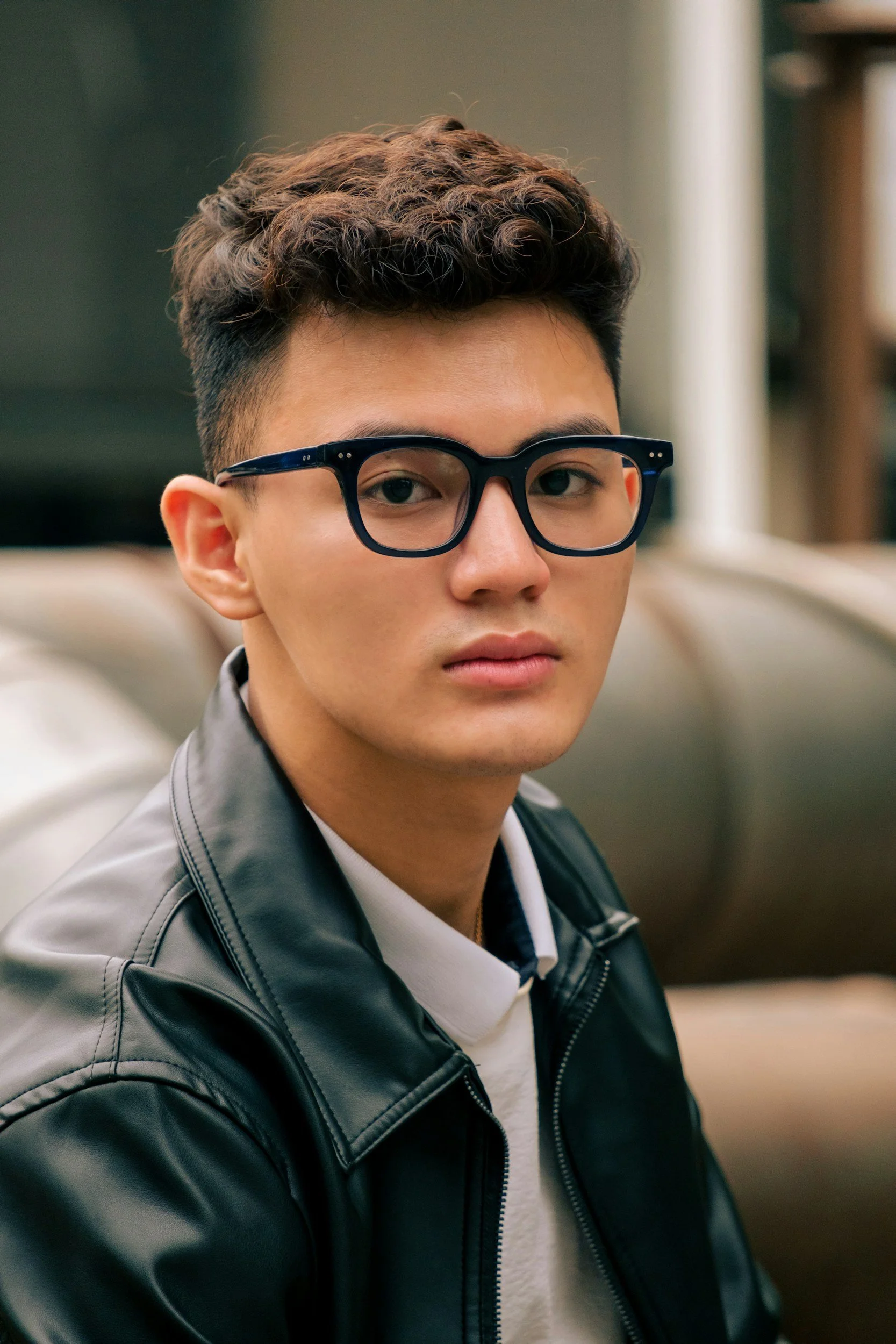 Young asian adult with short brown hair and glasses contemplating polyamory therapy in Concord, NC