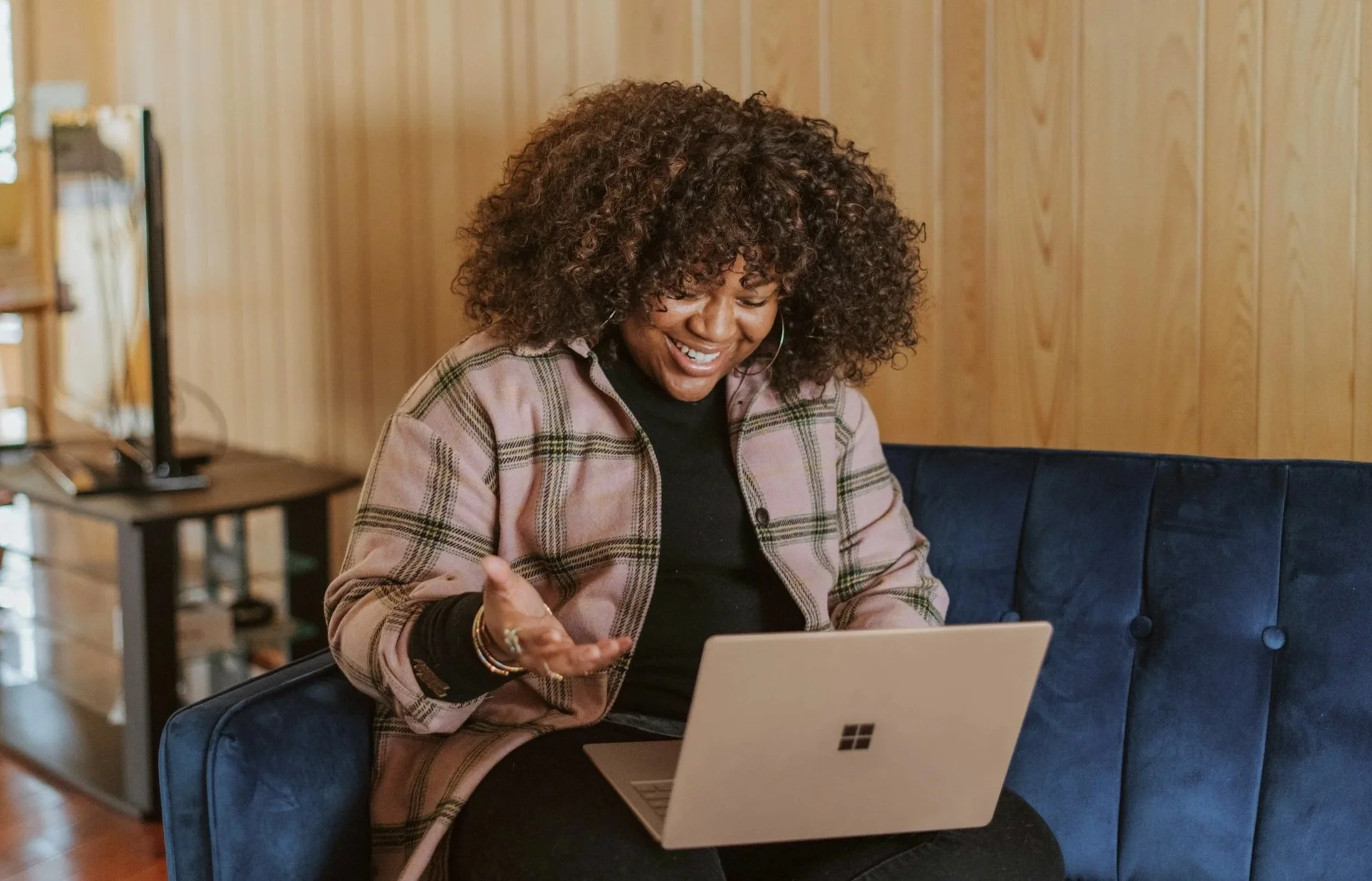 Black woman sitting on blue coach on online childhood therapy session near Concord, NC
