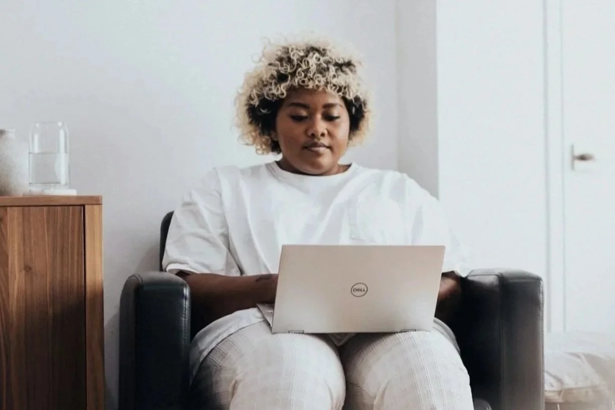 black female siting in chair using laptop for therapy session