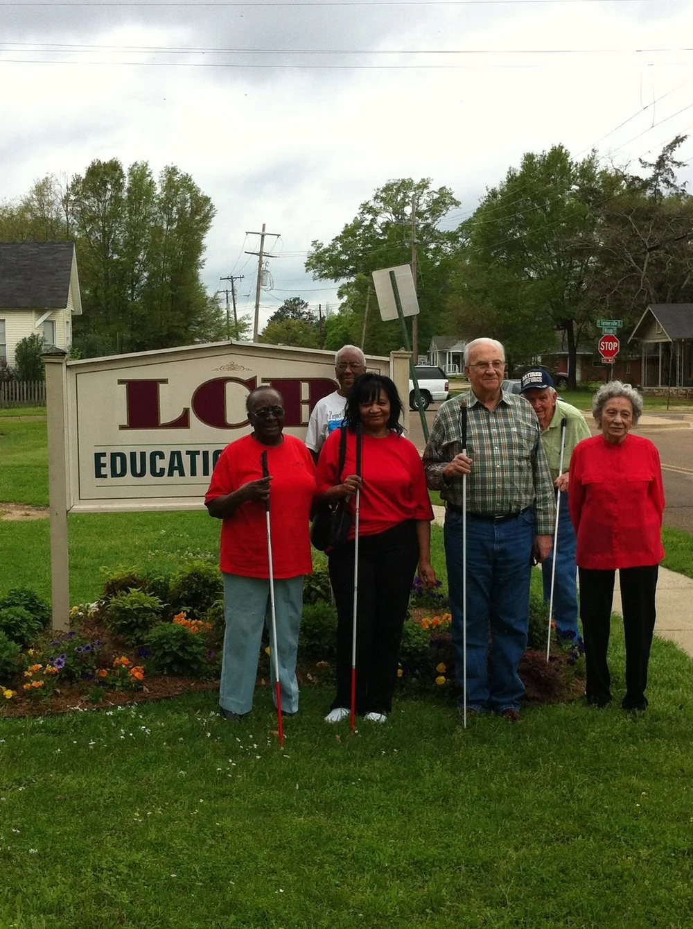 Group of TLC students in front of LCB education center sign