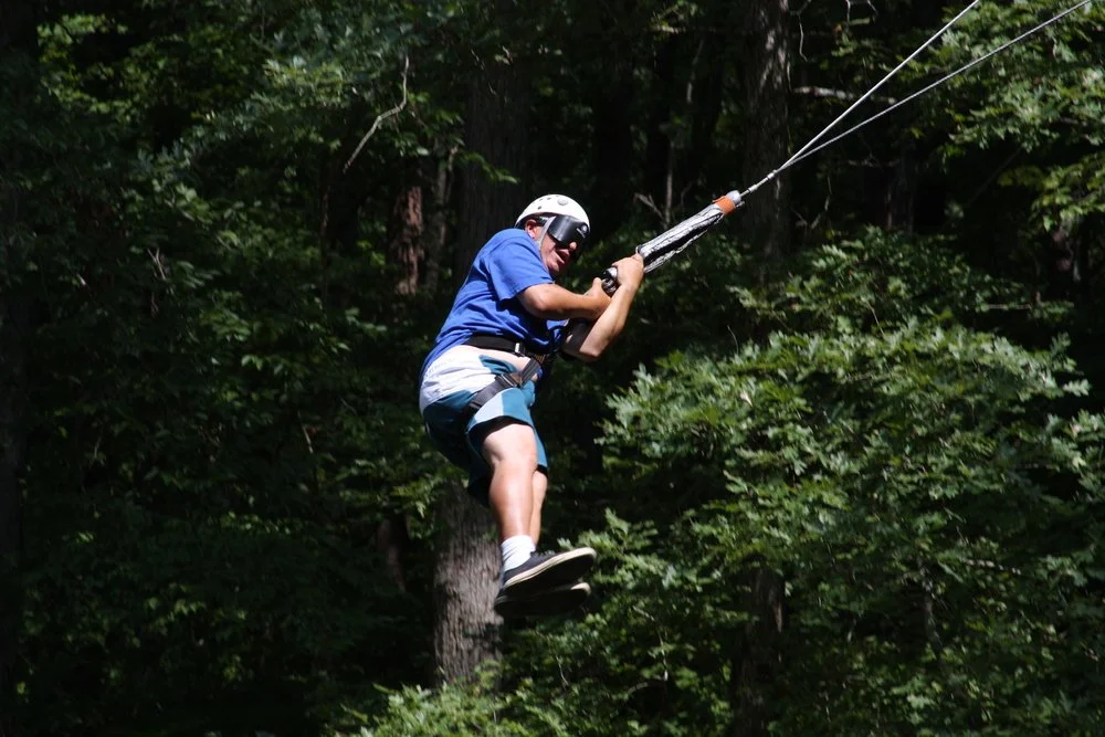 LCB Student on a zipline in the woods