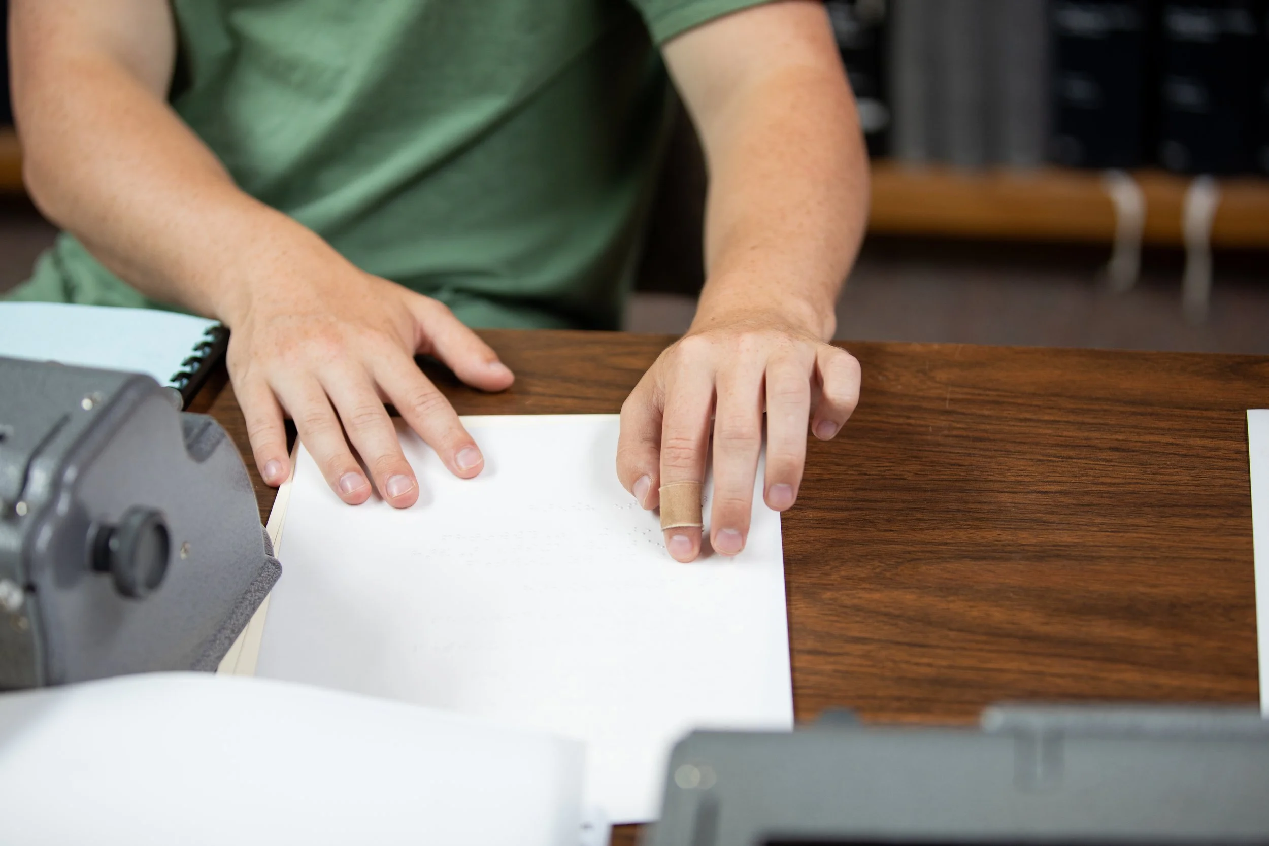 Student reading braille in braille class