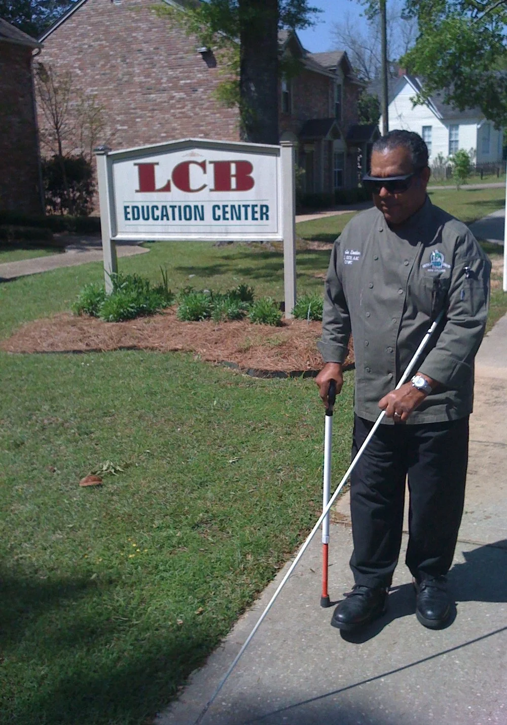 LCB TLC Student walking with cane outside of LCB education center