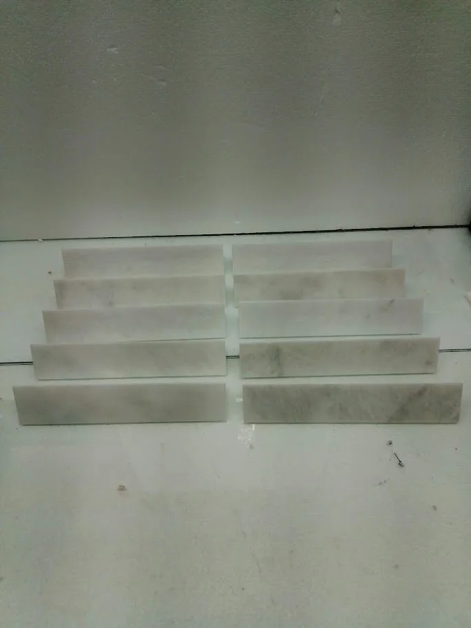 Two rows of marble lunges or step blocks placed on the floor in front of a wall.