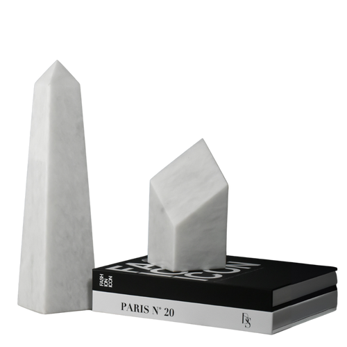 Two white marble obelisks and a black and white book titled "PARIS N° 20" on a black surface