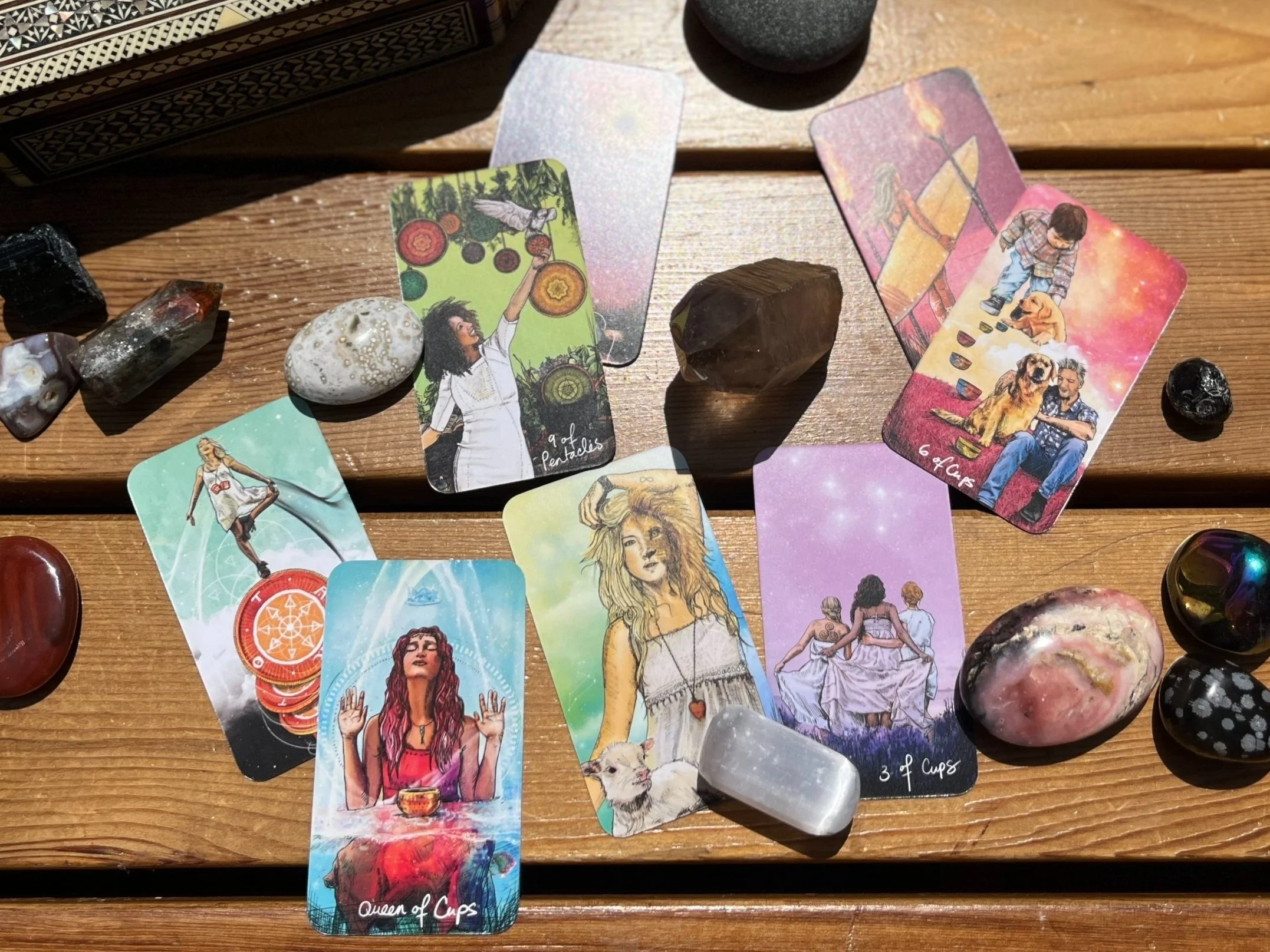 Modern wooden building with large glass window set against a mountainous landscape with grassy terrain and sparse trees in the foreground.