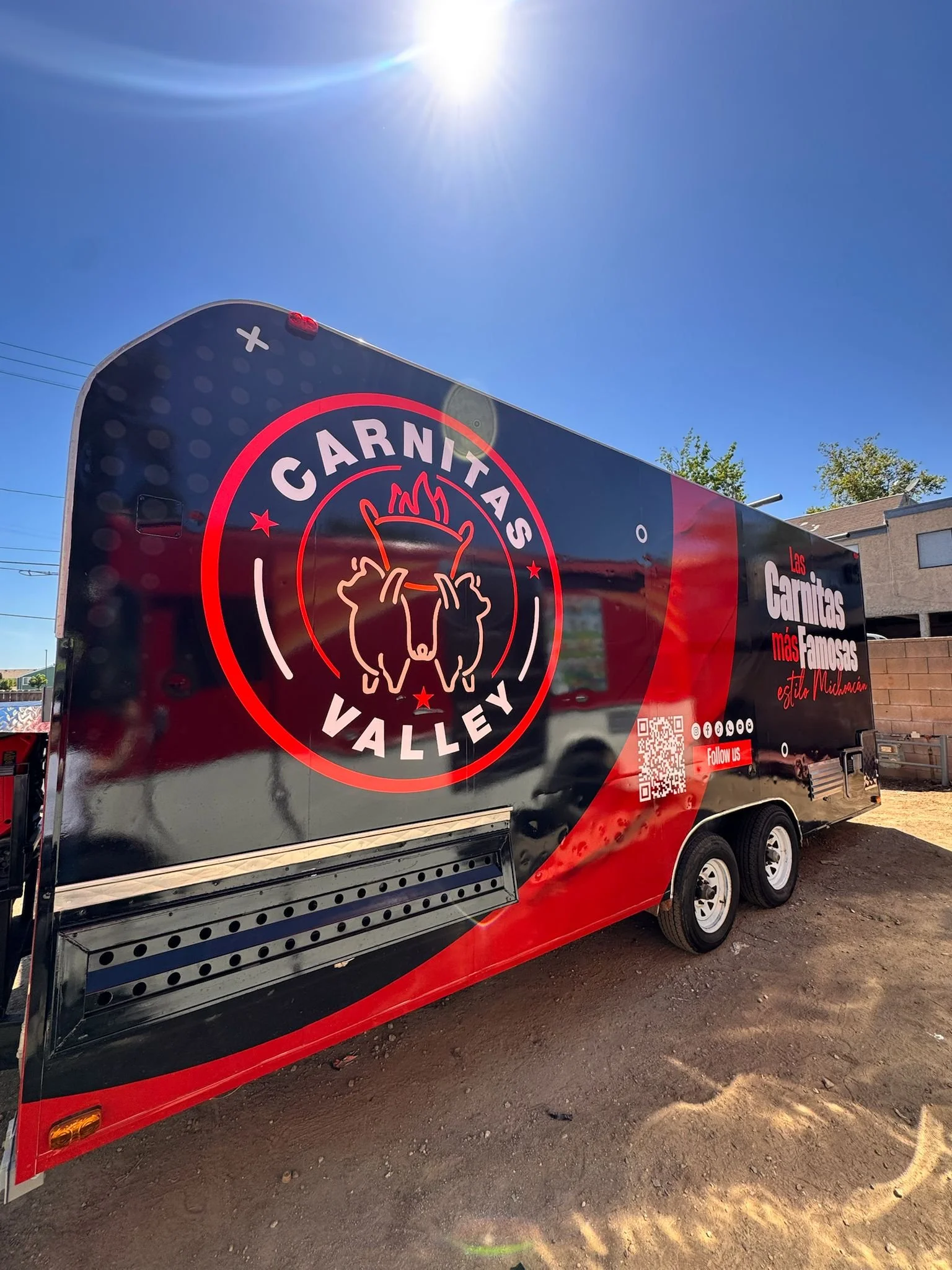 Food truck with black and red exterior featuring a logo of a pig's face with fork and knife, and text promoting a Mexican meat brand | Grizzly Signs | Los Angeles, CA | Custom Wraps