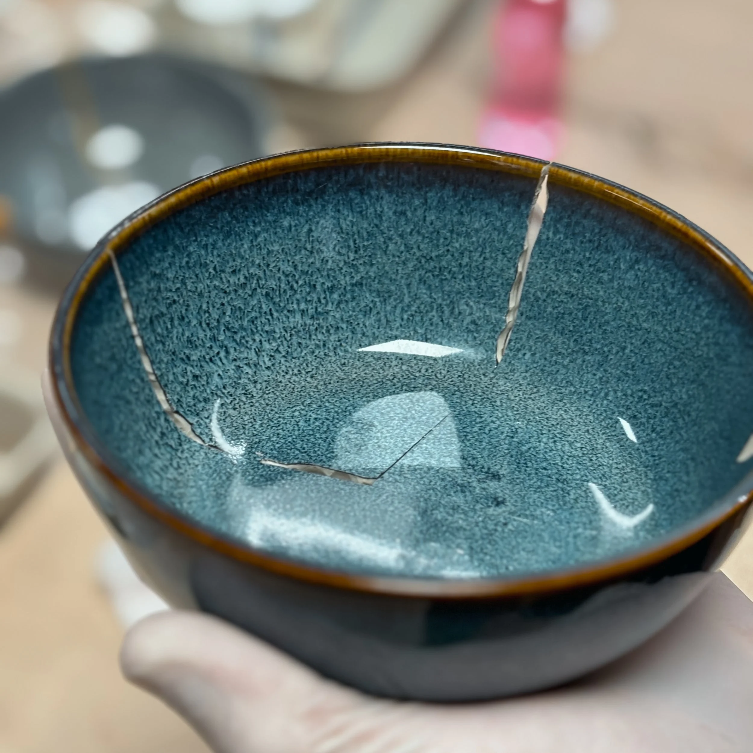 Ciotola di ceramica blu con crepe evidenti.