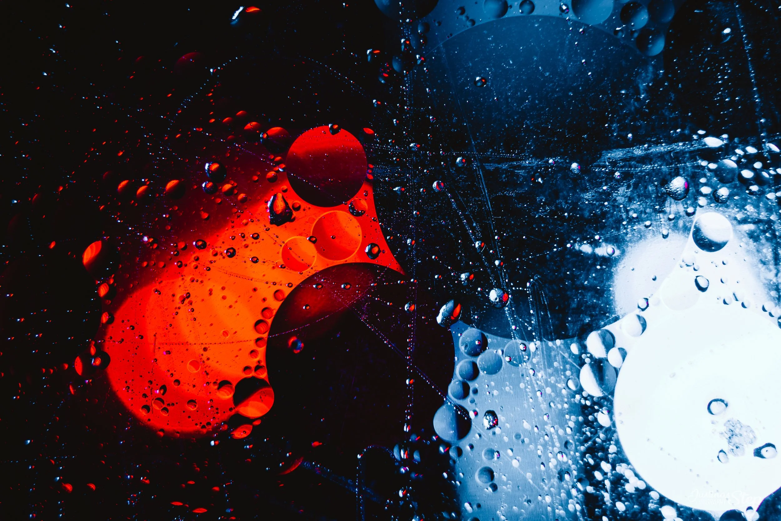 Abstract image of colorful circles and bubbles in red, white, and black on a dark background.