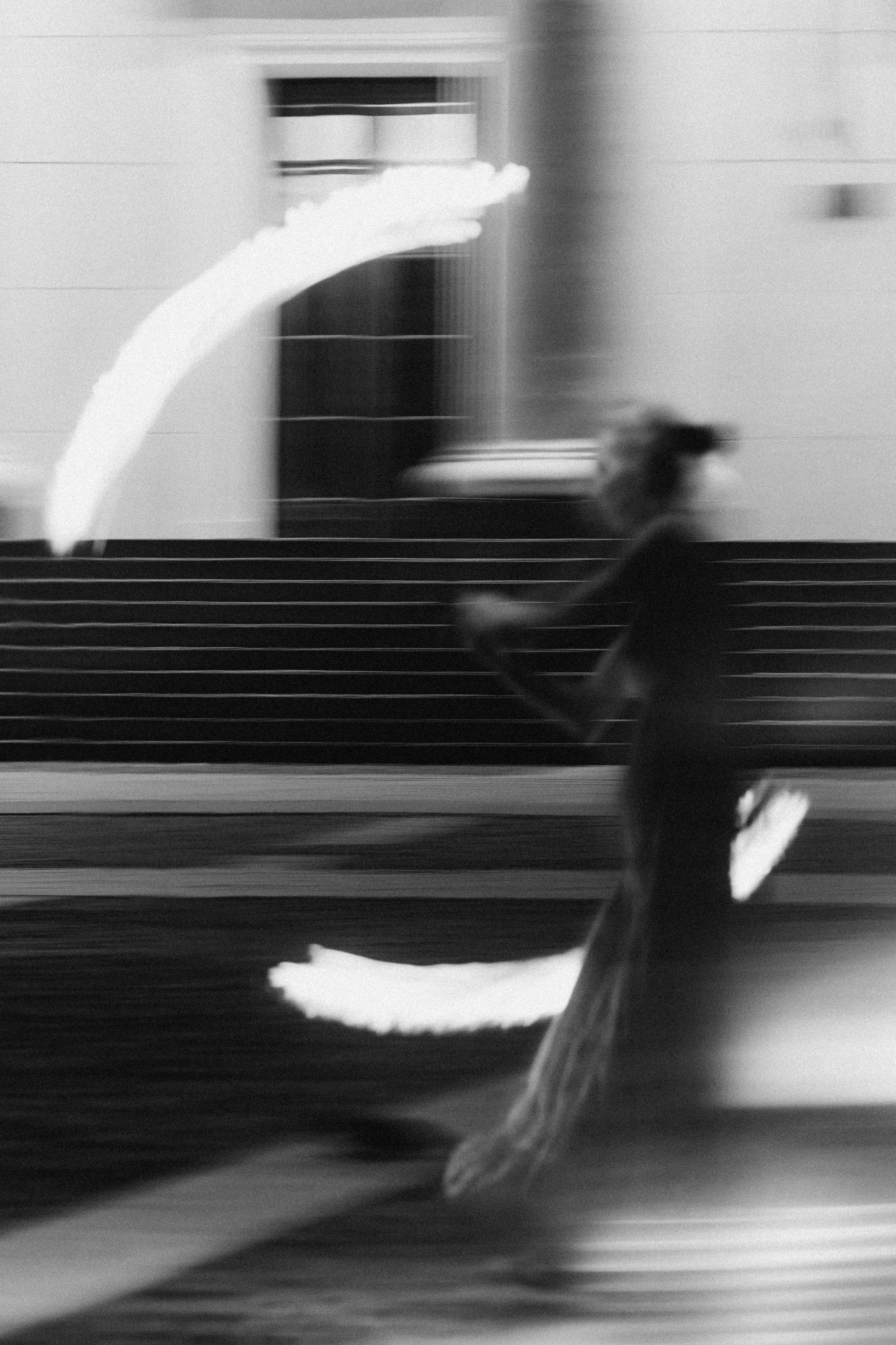 A person jogging along a street at night, with moving light streaks in the background and foreground, creating a blurred motion effect.