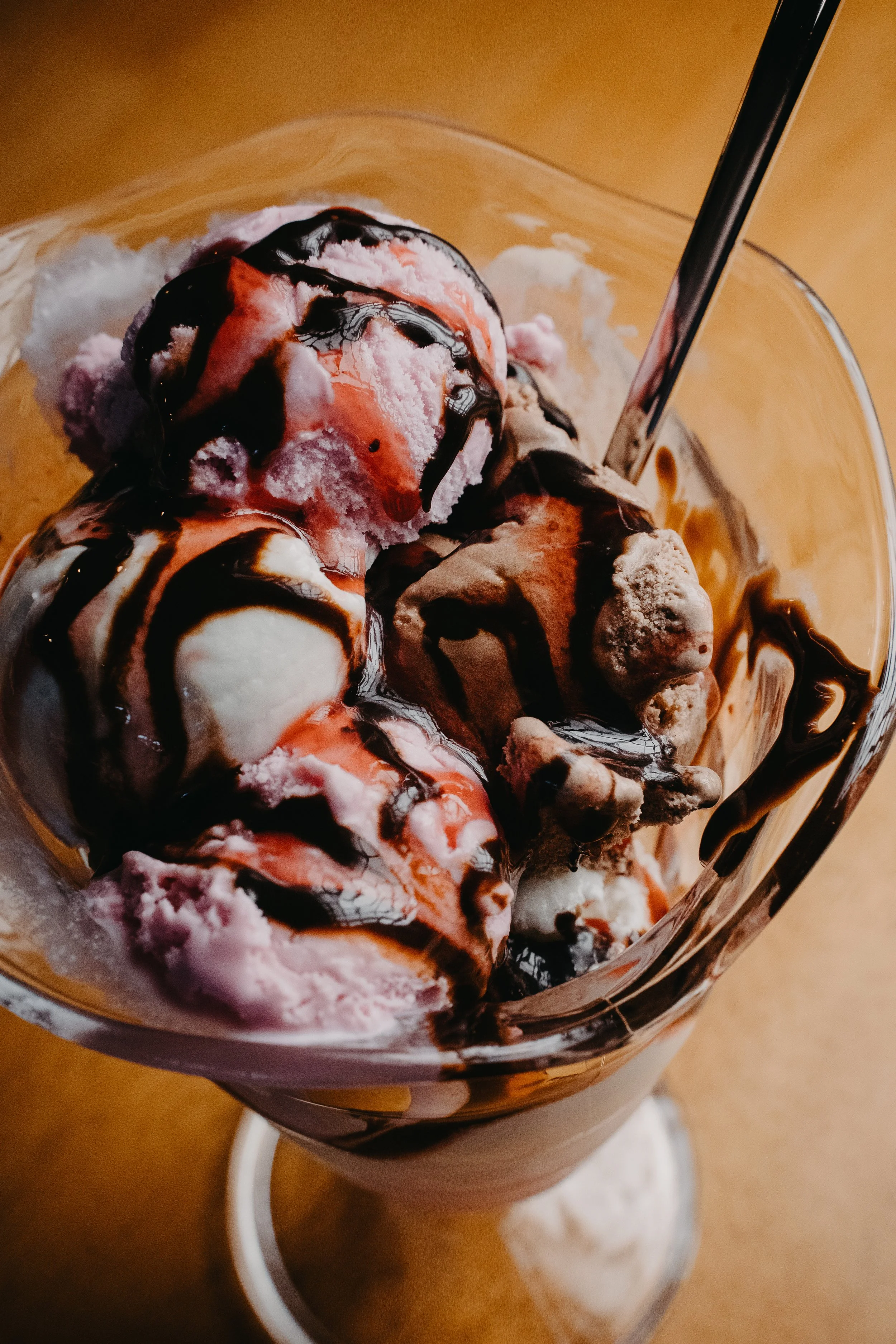 A glass of ice cream with chocolate syrup.