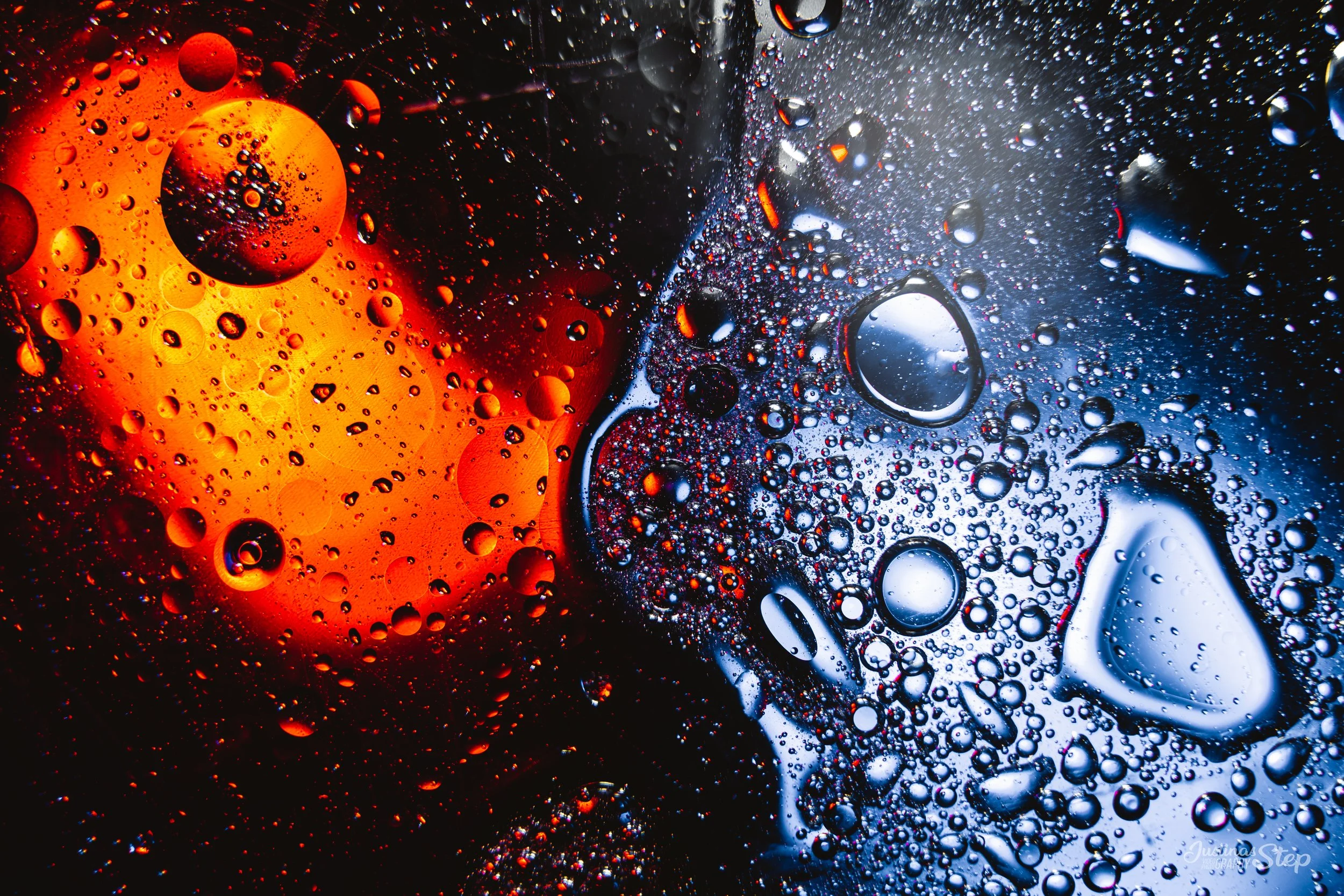 Close-up of bubbles in a carbonated beverage, with a fiery orange glow on the left and a cool blue glow on the right.