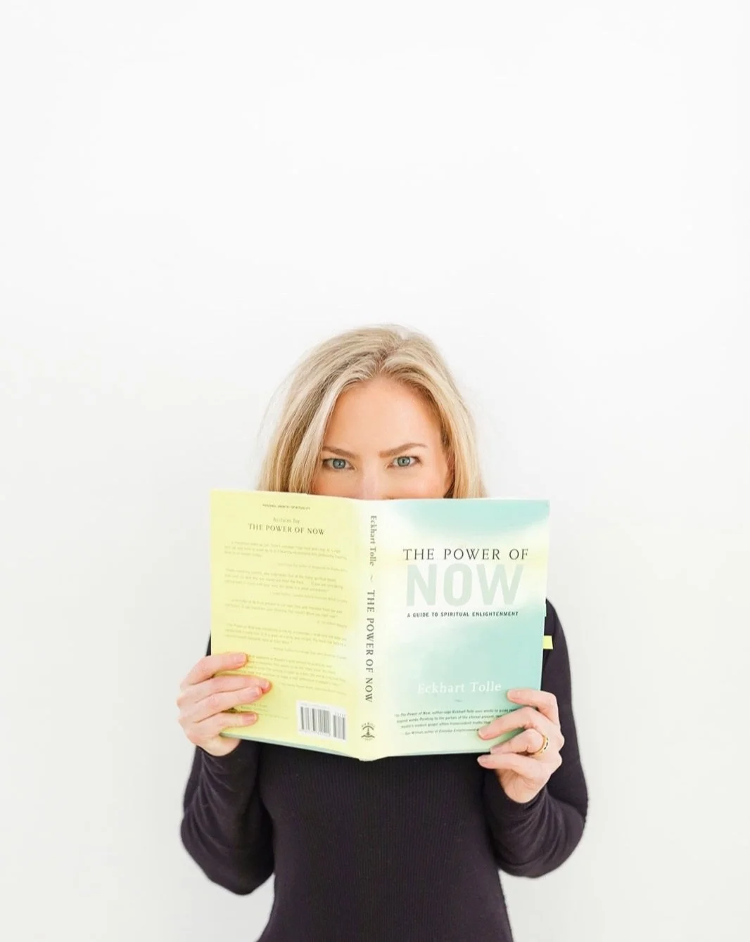 Author, Leadership and Life Design Coach Kathleen Branigan - a woman with blonde hair reading a book titled 'The Power of Now' against a white background.