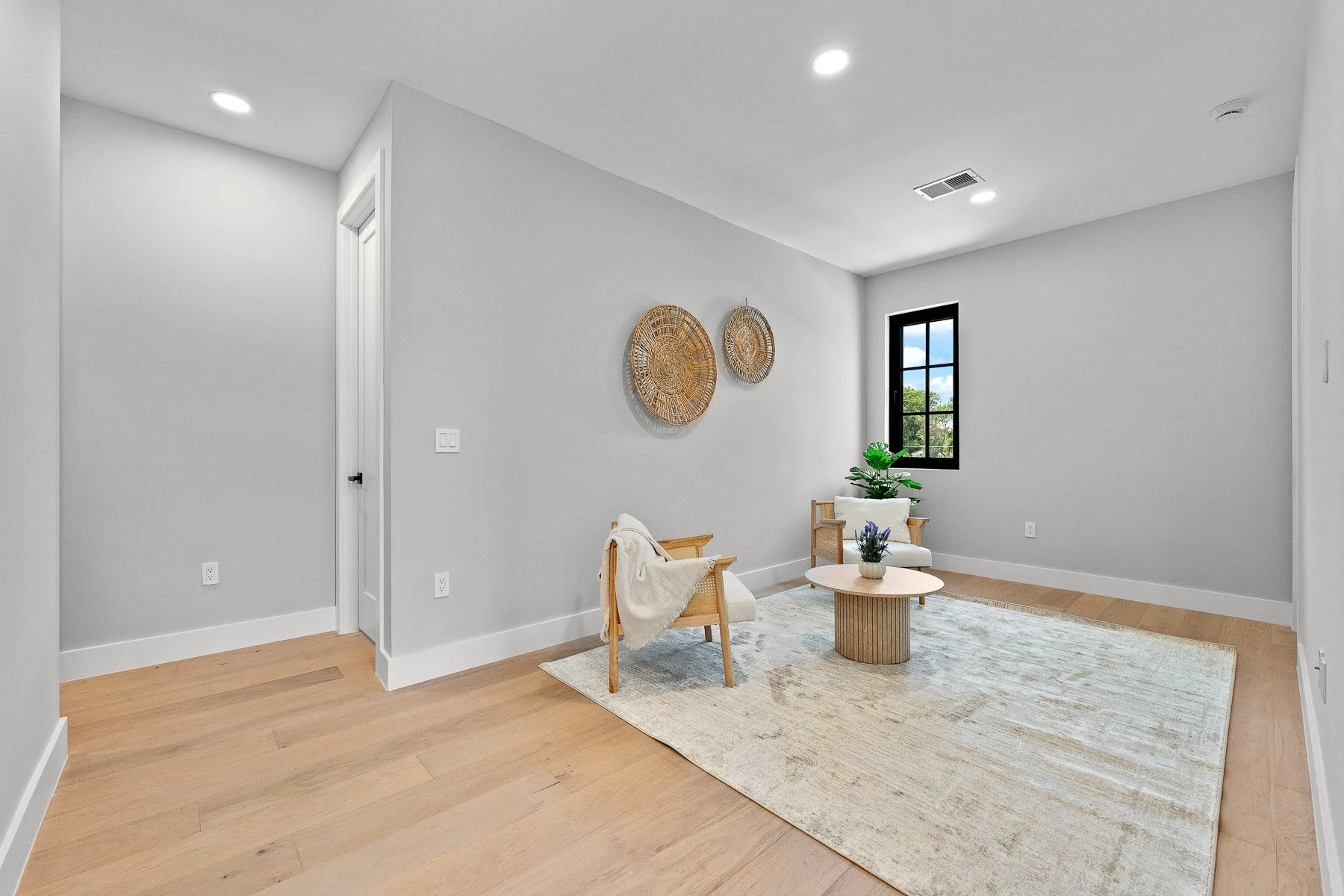 Modern kitchen with light wood cabinetry, white marble island, stainless steel refrigerator, open shelving, three pendant lights, and wood flooring