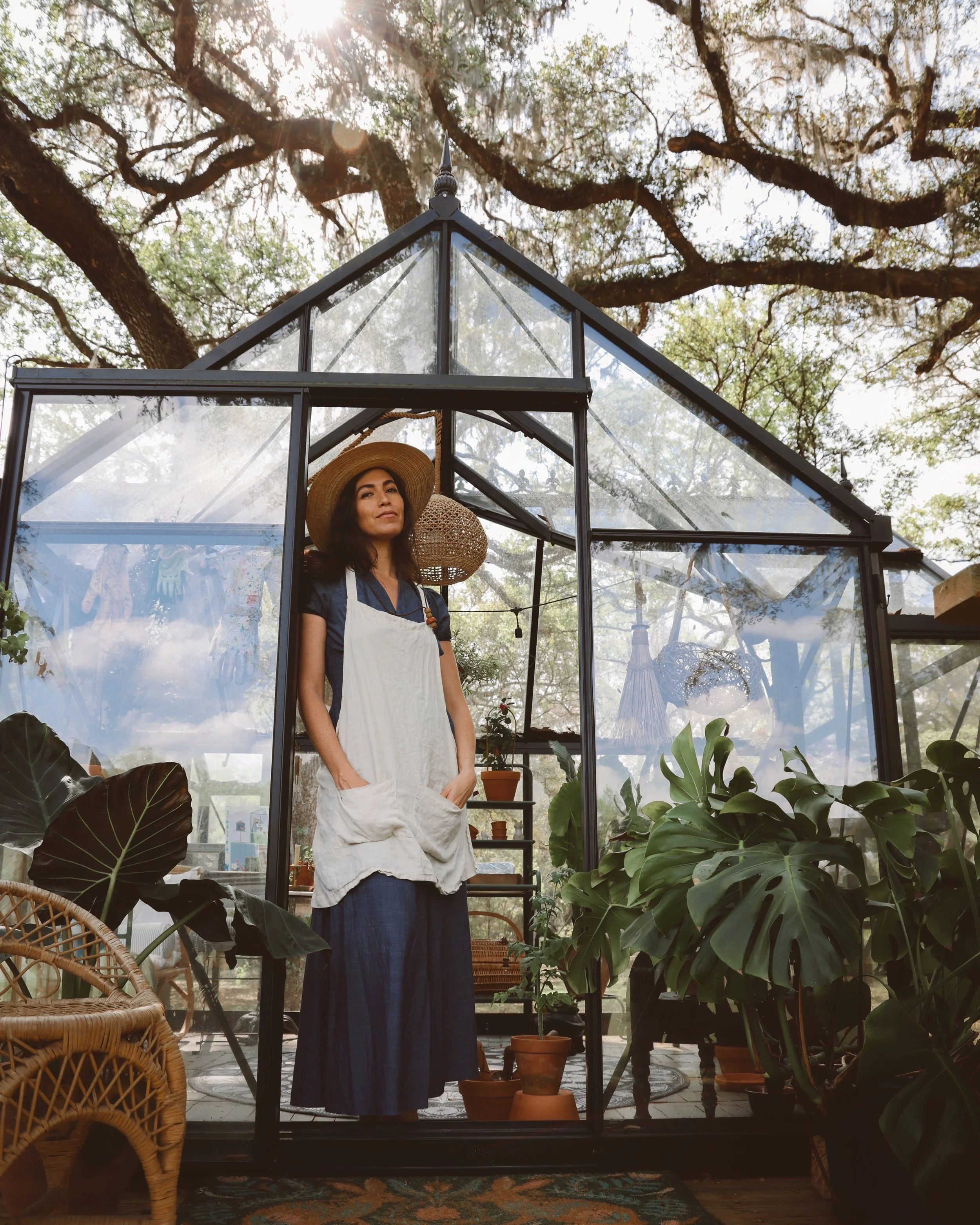 Whitney Leigh Morris in a tiny greenhouse in the woods