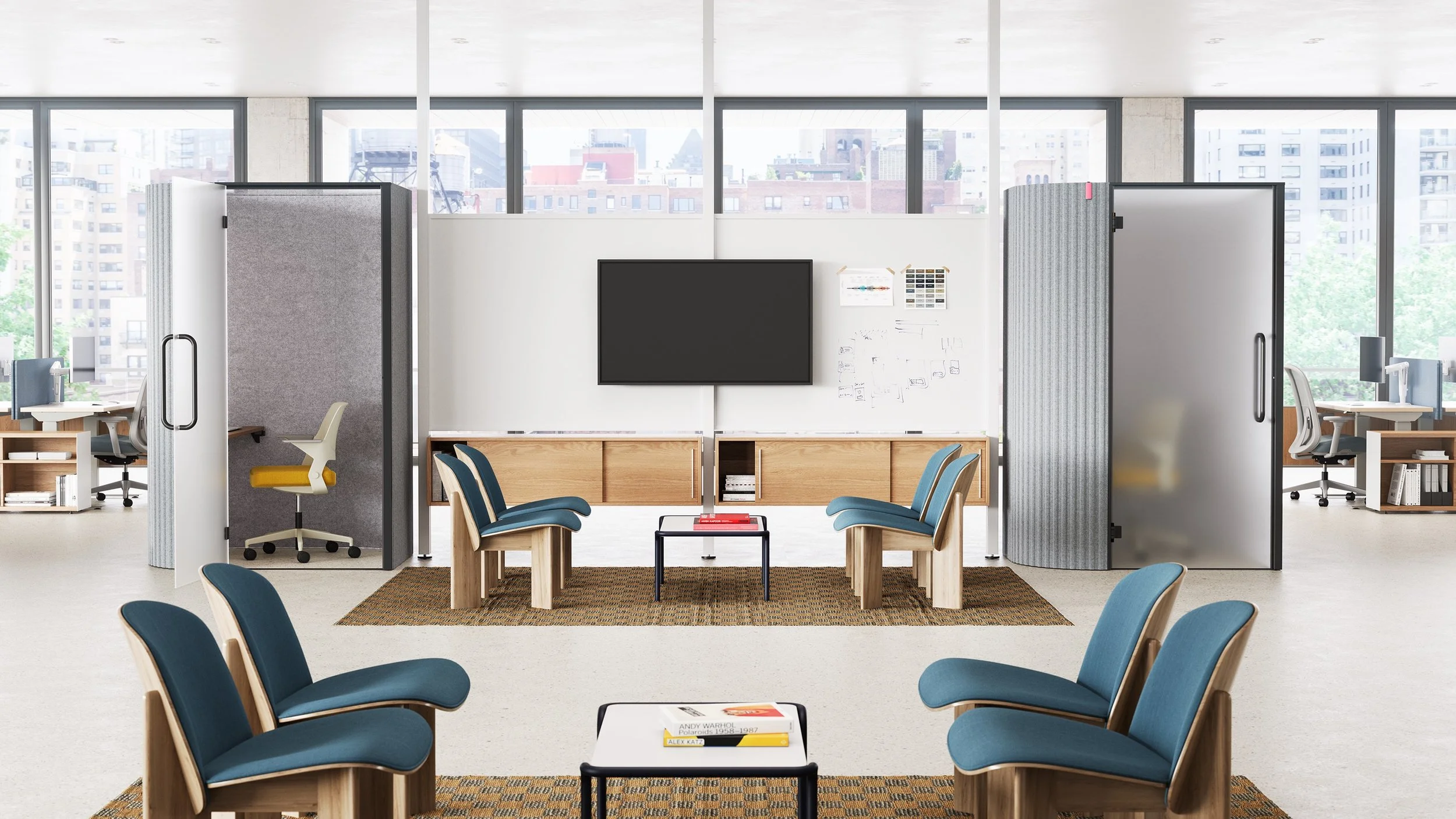 Modern office space with a whiteboard, chairs, a TV, and private work booths with white walls and blue chairs.
