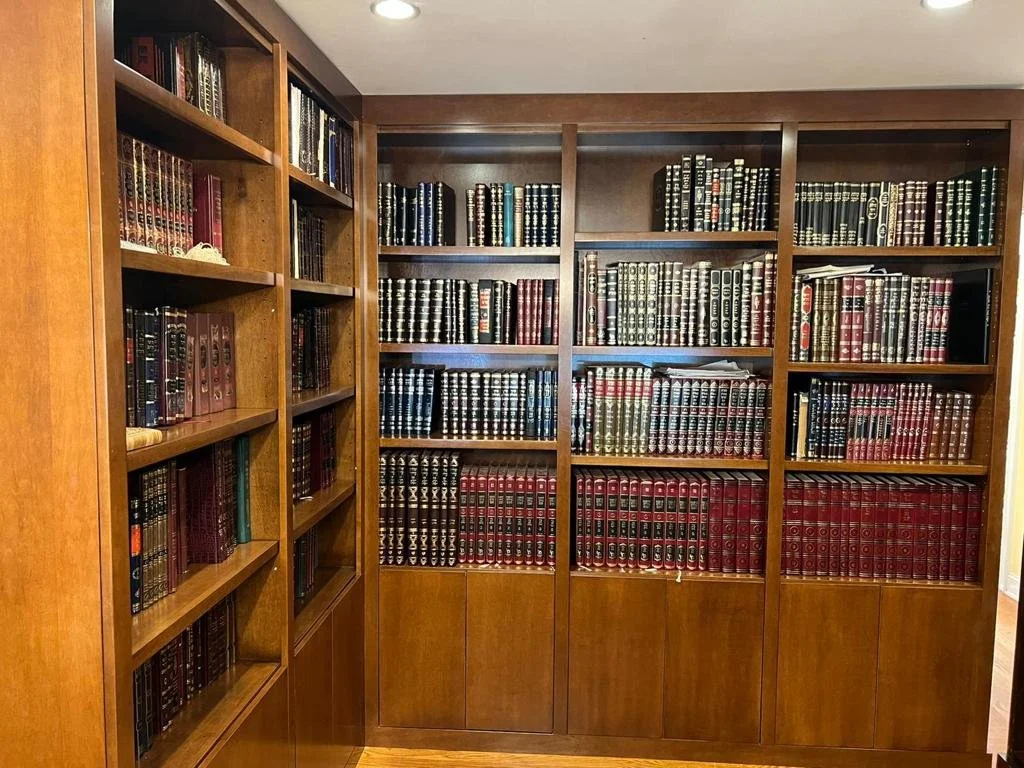 Wooden bookshelf filled with organized textbooks and books in a library or study room.