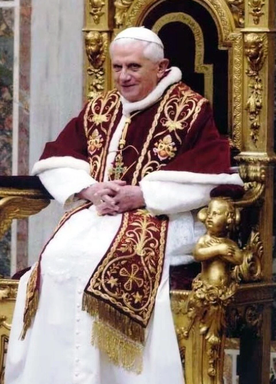 El Papa Benedicto XVI sentado en el trono papal. Fuente: Wikimedia Commons. Uso no comercial, sin alteraciones.