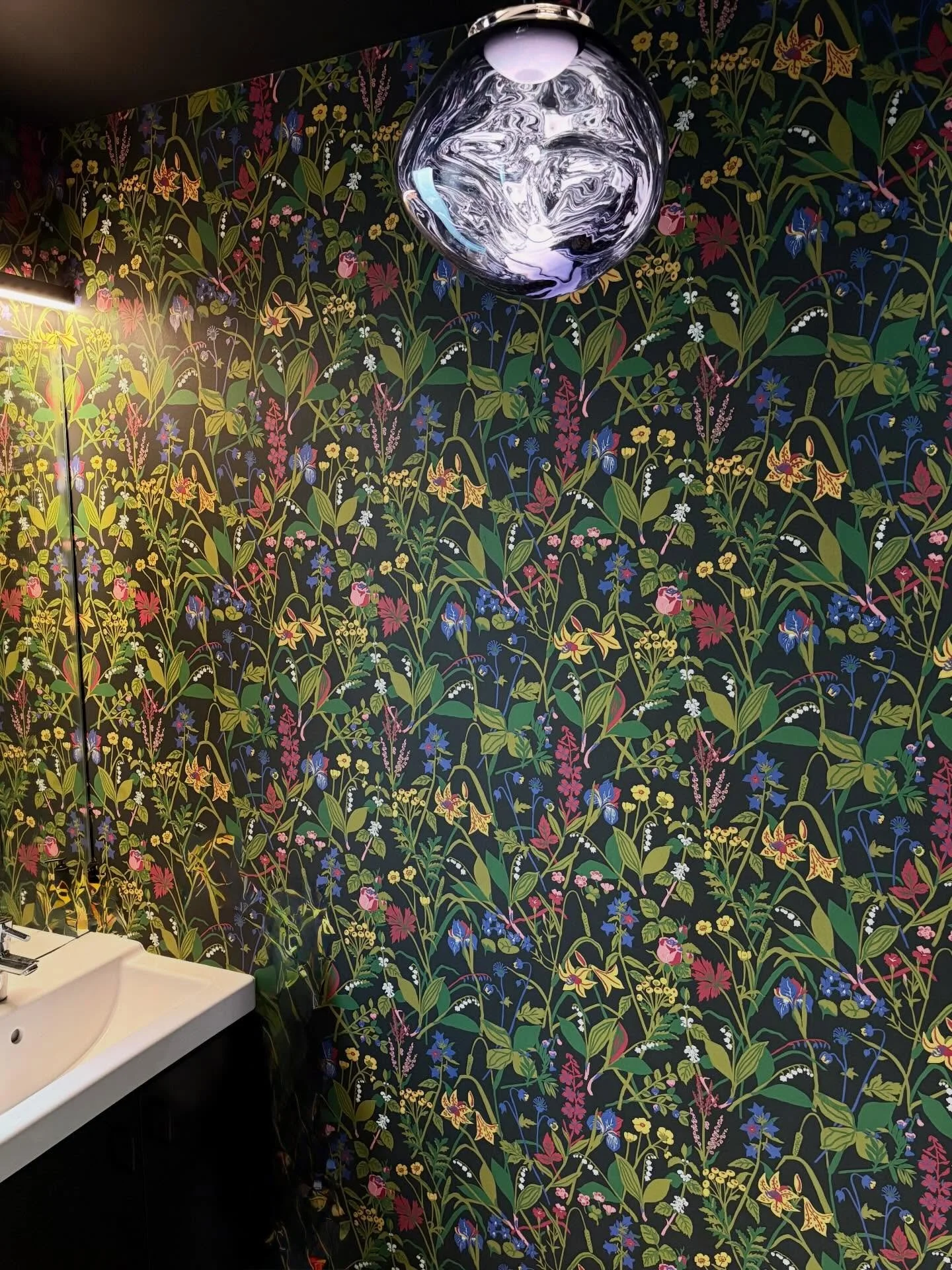 Wallpaper from @borastapeter in the bathrooms of the Irvington condo.

A black-grounded multi floral in the half bath paired with a @tomdixonstudio melt pendant creates a dark mood.

And a feminine brown floral reinvigorates the original brown tile i