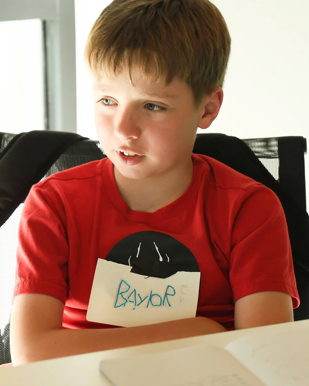 Young man named Baylor sits at a table at the collaboration meeting.