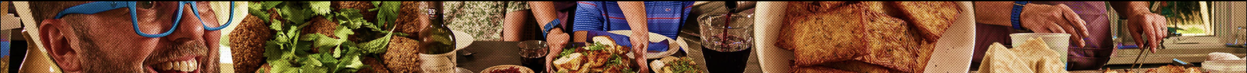 People dining at a table with food including salad, fried chicken, and bread, during a meal celebration.