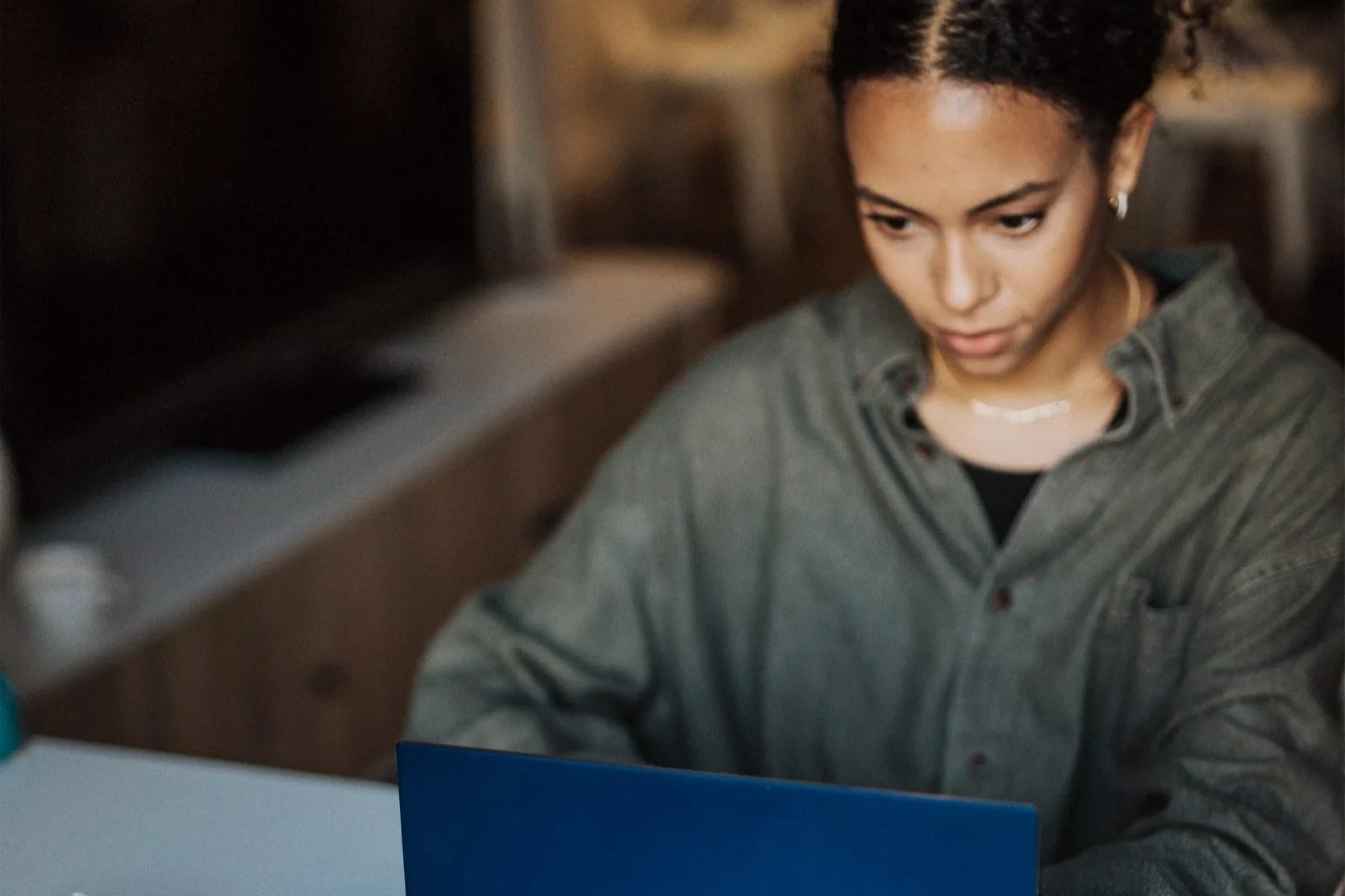 woman with curly hair looking at a laptop screen