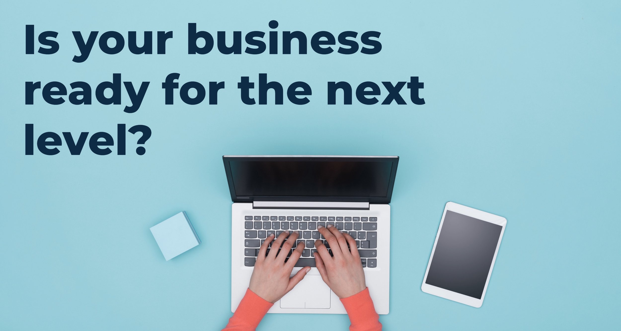 Clean workspace with laptop and tablet displaying “Is your business ready for the next level?” representing a small business preparing to invest in professional marketing.