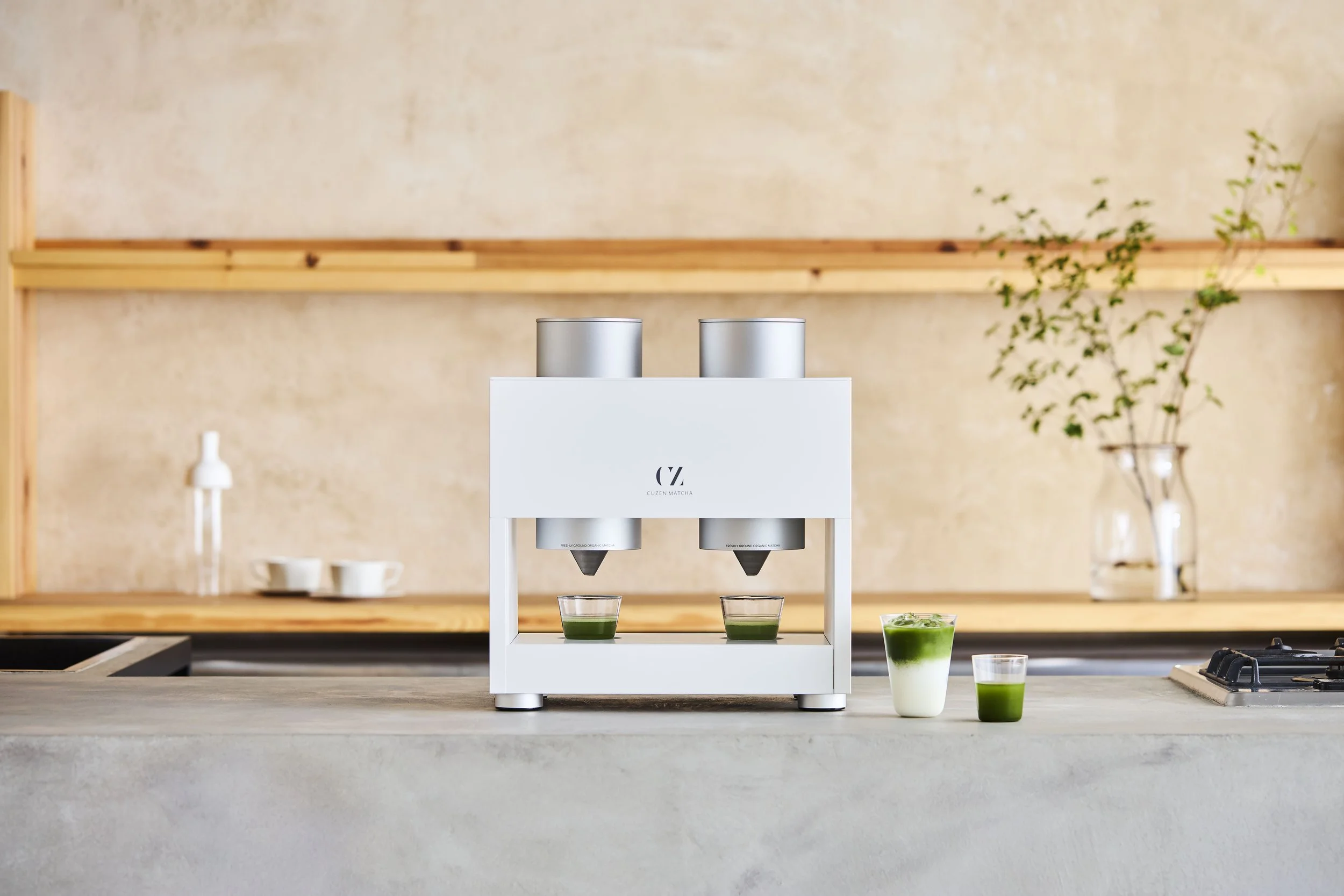 Cuzen Matcha Maker milling fresh matcha from whole tea leaves into two glasses