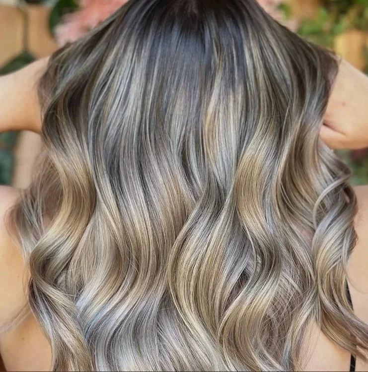 Close-up of long, wavy blonde hair with darker roots.