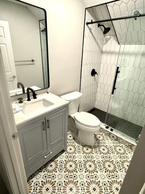 Renovated bathroom with new black fixtures.