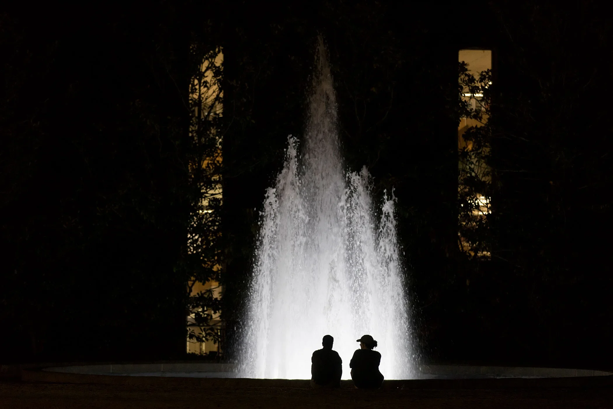 A couple talks in front of Herty Field Fountain at night. (Photo by Andrew Davis Tucker/UGA)