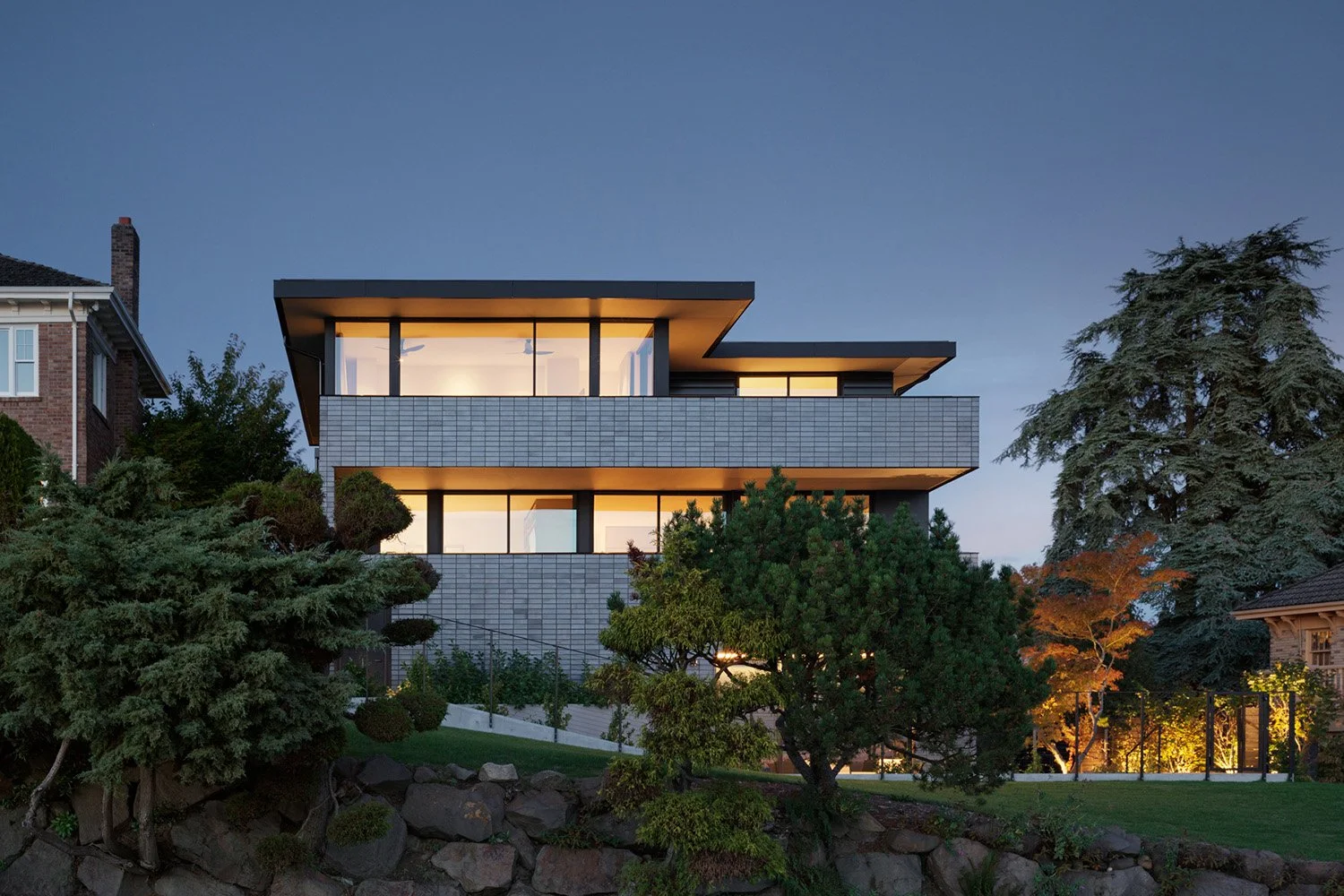 Rear elevation of modern brick house with strips of large windows and doors