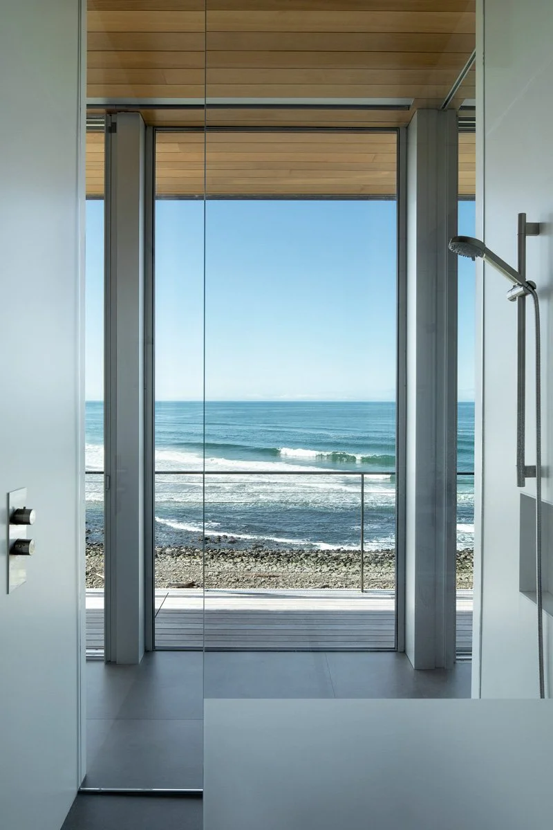 Modern Bathroom with glass wall in the shower looking to view of the ocean