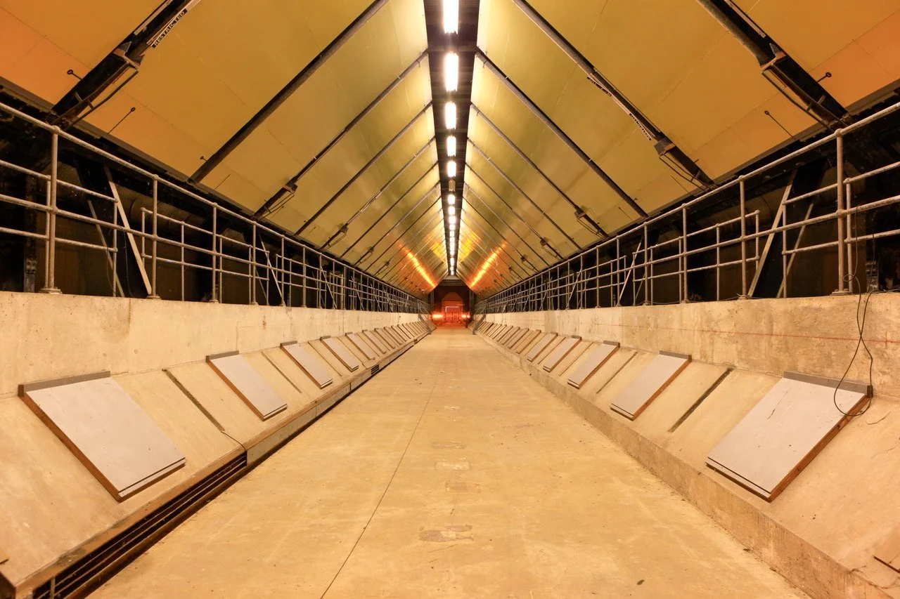 Pasillo largo tecnológico con iluminación y paneles laterales en construcción o reparacion