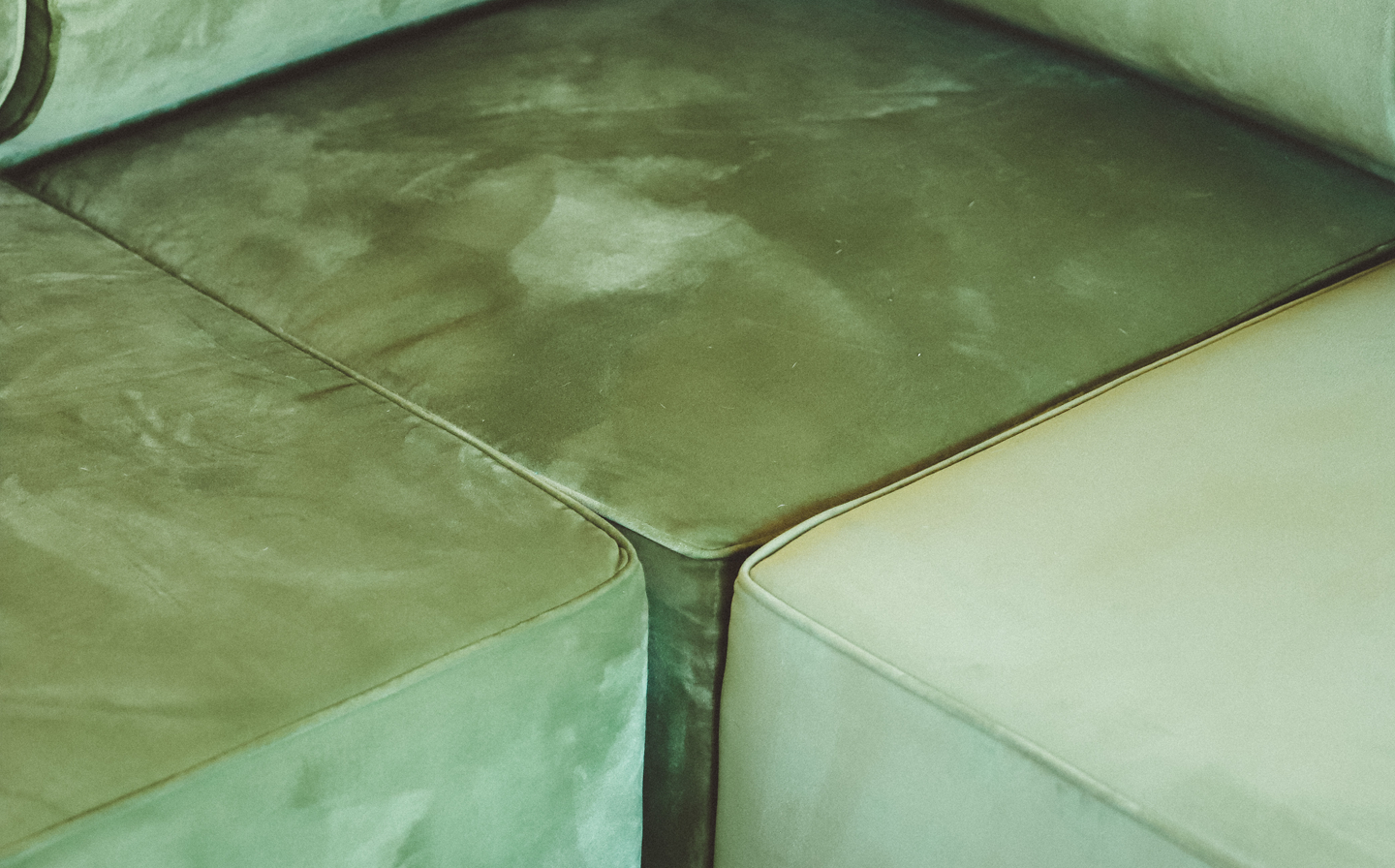 Tres sillones de cuero en tonos verdes y beige con marcas de uso.