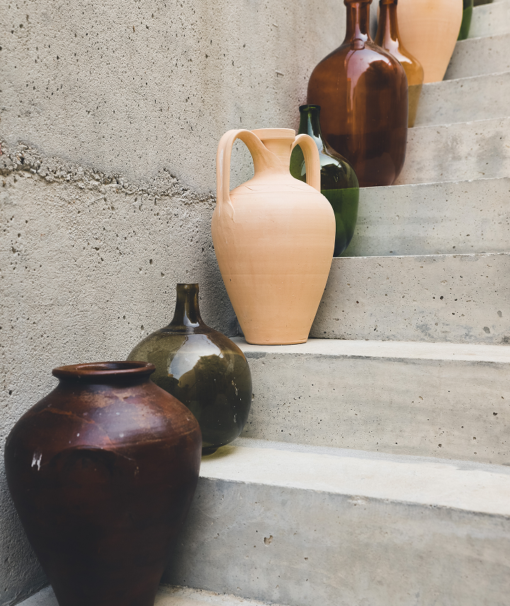 Vasos de cerámica y vidrio en una escalera de concreto.