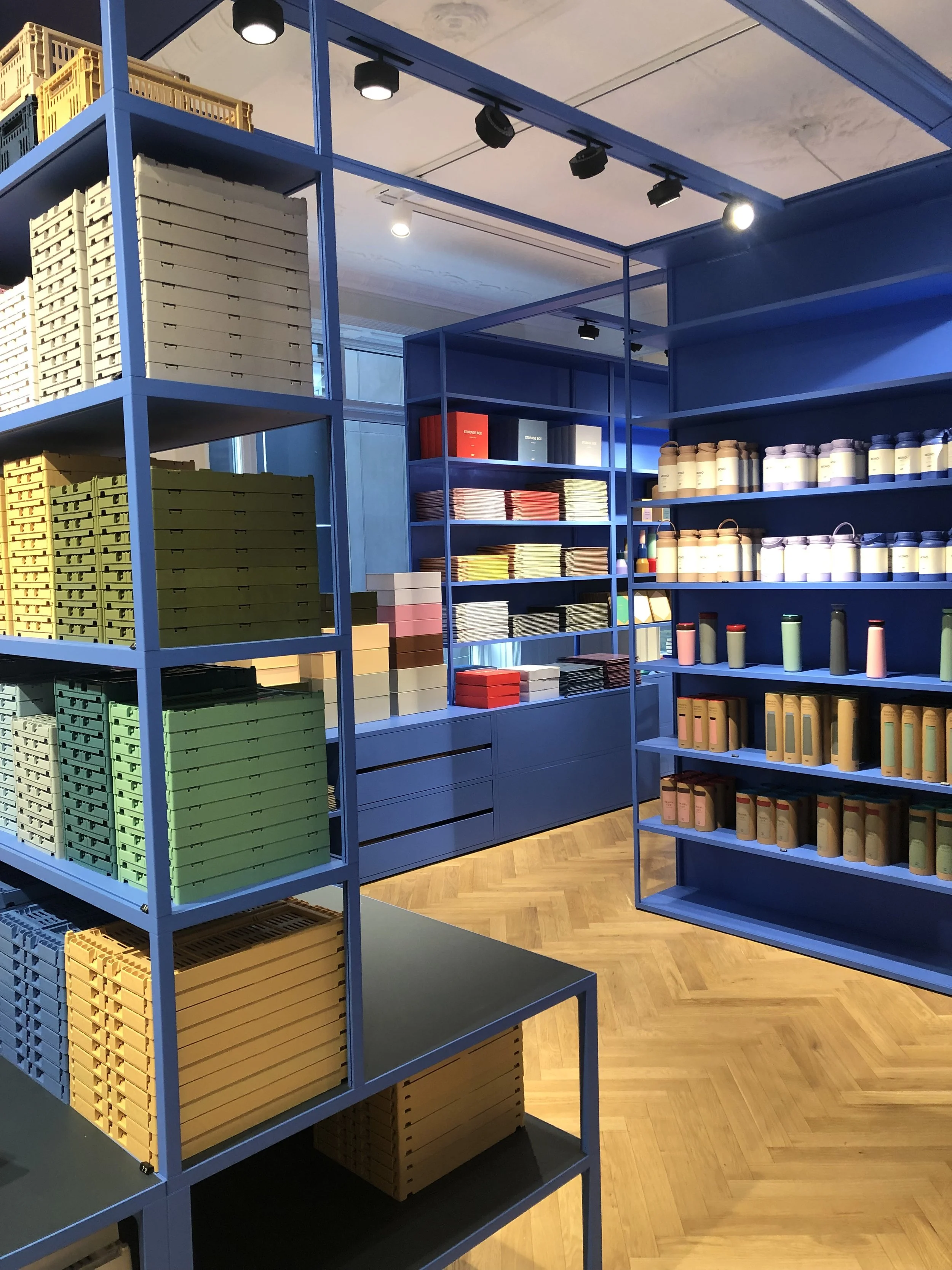 Estanterías en una tienda con varios tipos de cajas de diferentes colores y algunos frascos en las paredes.