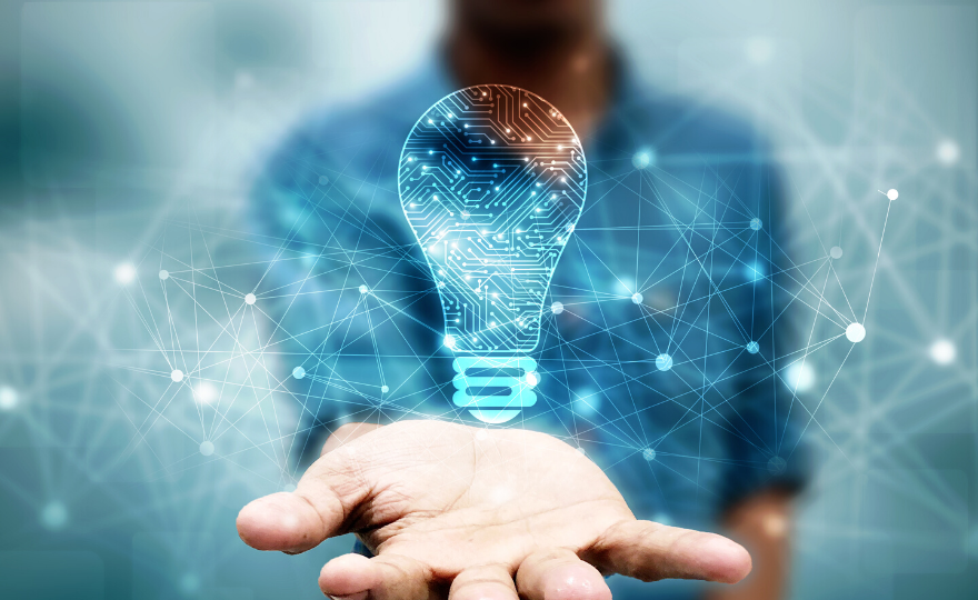Person holding out hand with digital light bulb icon and network connections in the background.