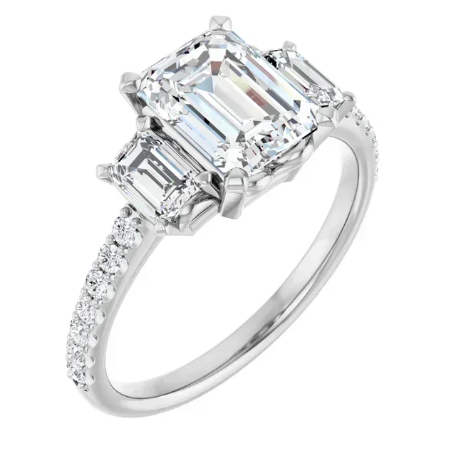 A silver ring with a large rectangular center diamond flanked by two smaller rectangular diamonds and a band of small diamonds.
