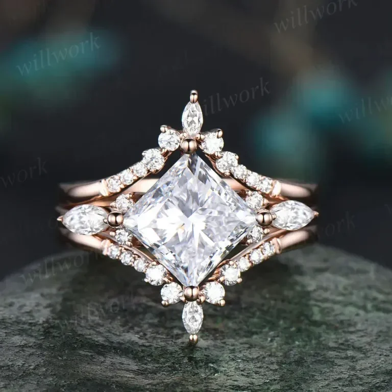 Close-up of a diamond ring with a large square-cut center stone surrounded by small diamonds in a floral and geometric design on a dark surface.