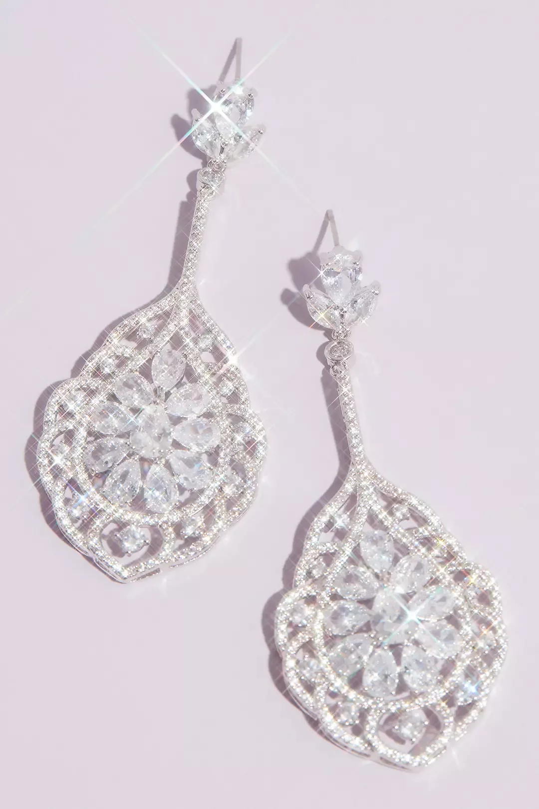 Sparkling silver and diamond chandelier earrings on a light background.