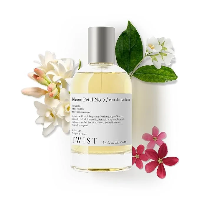 A bottle of Bloom Petal No. 5 perfume from TWIST surrounded by white, pink, and red flowers with green leaves.