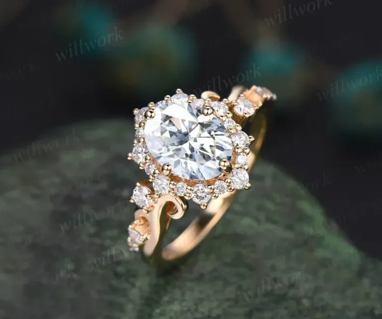 Close-up of a gold ring with a large central diamond surrounded by smaller diamonds, resting on a dark green surface.