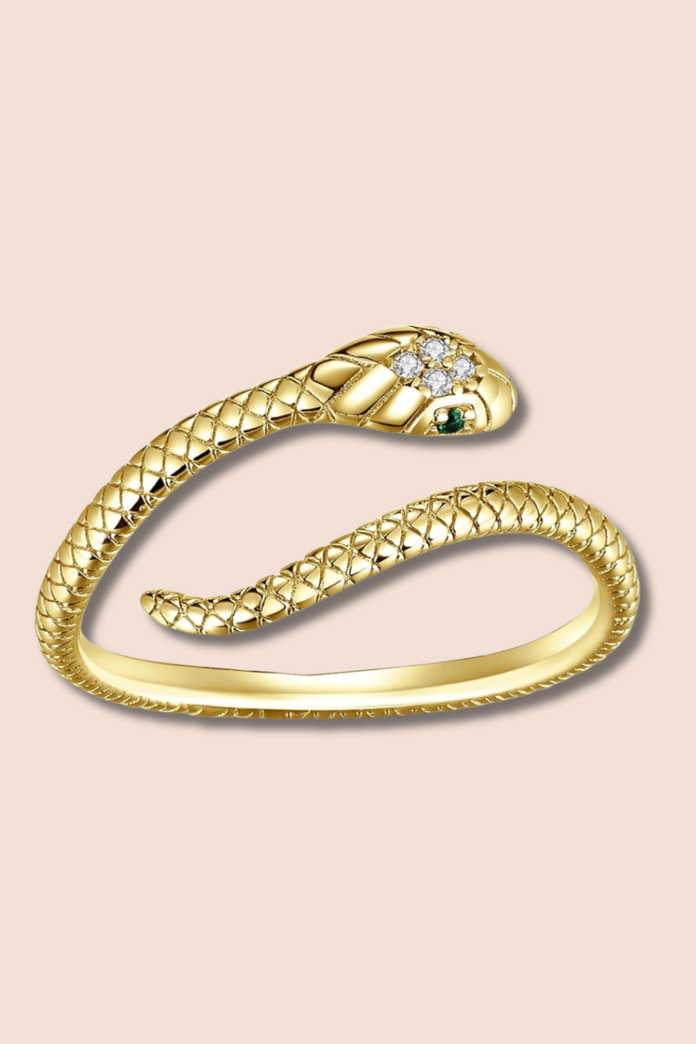 Gold snake-shaped ring with diamond and emerald accents on a pink background.