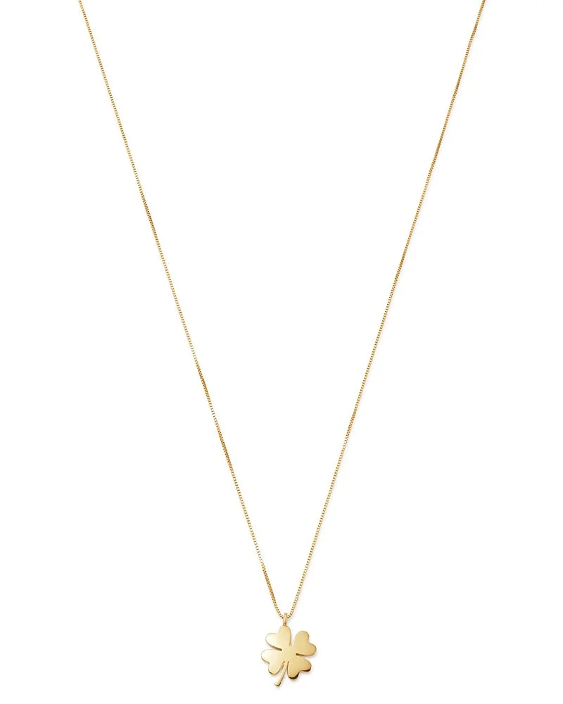 A gold necklace with a four-leaf clover pendant.