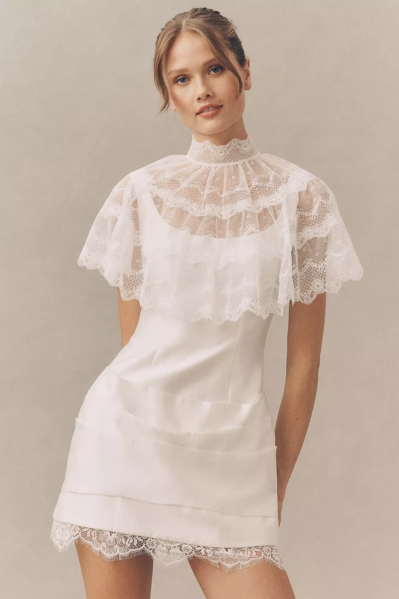 Female model in a white lace top and matching lace shorts posing against a plain background.
