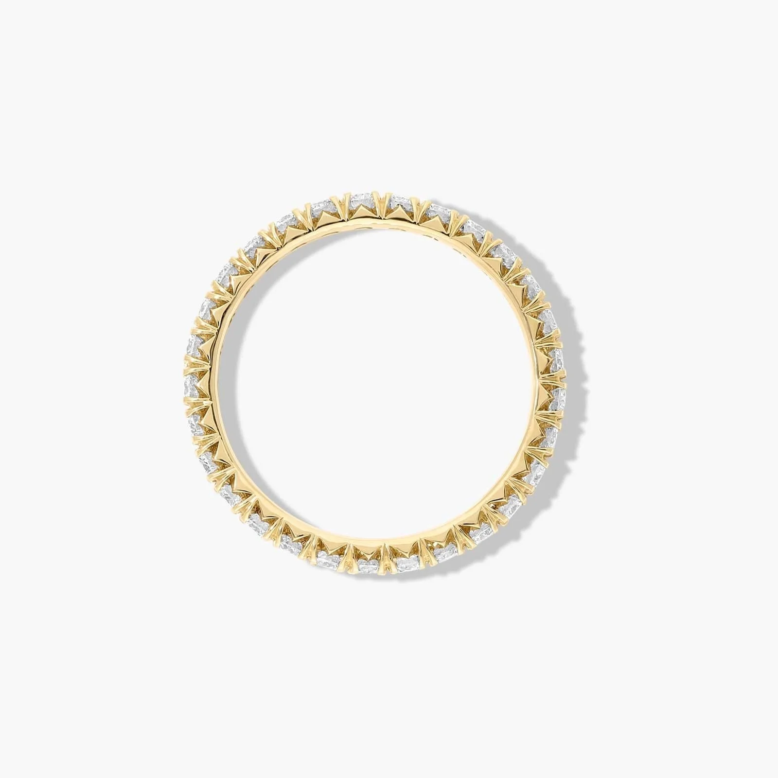 Gold ring with diamond accents and pointed prong details on a white background.